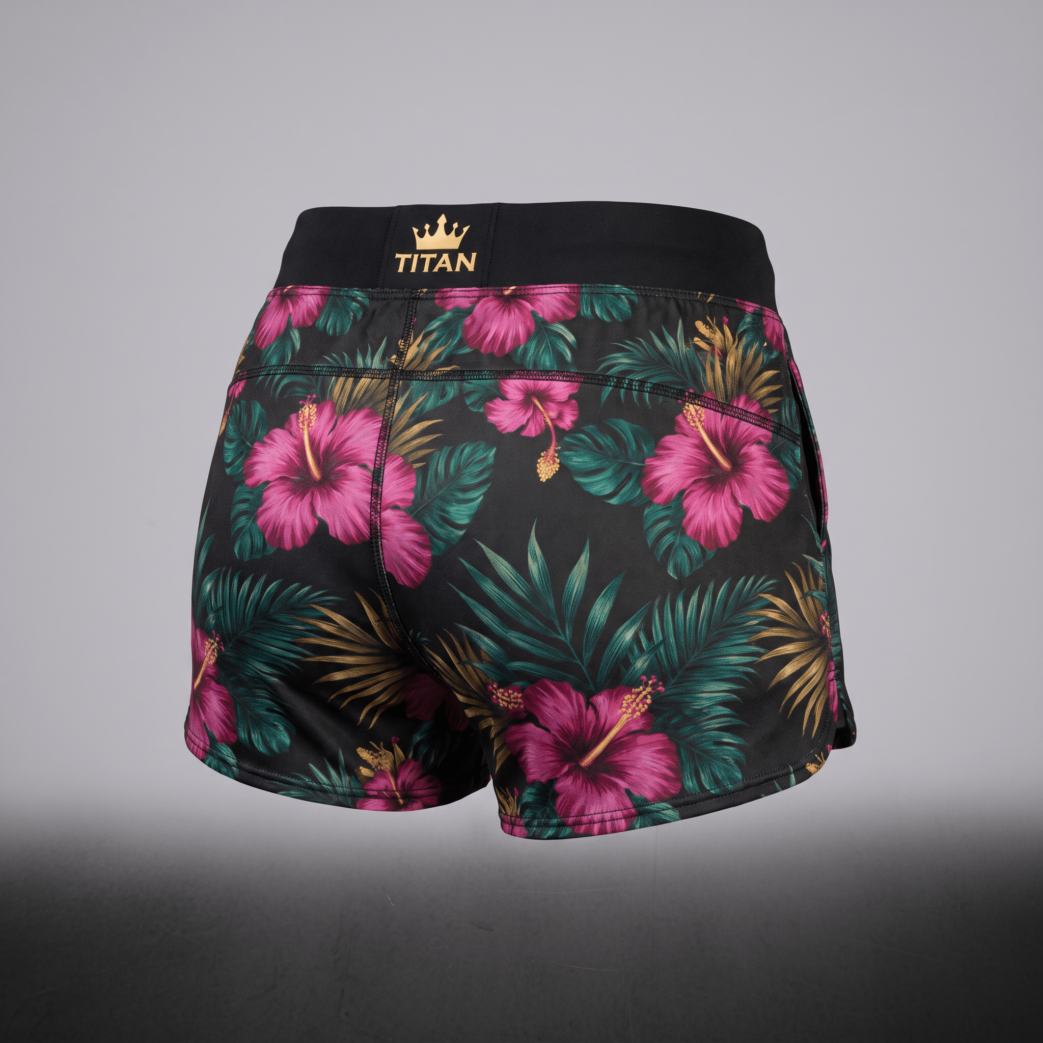 Back view of black athletic shorts with pink floral tropical print and gold Titan waistband.