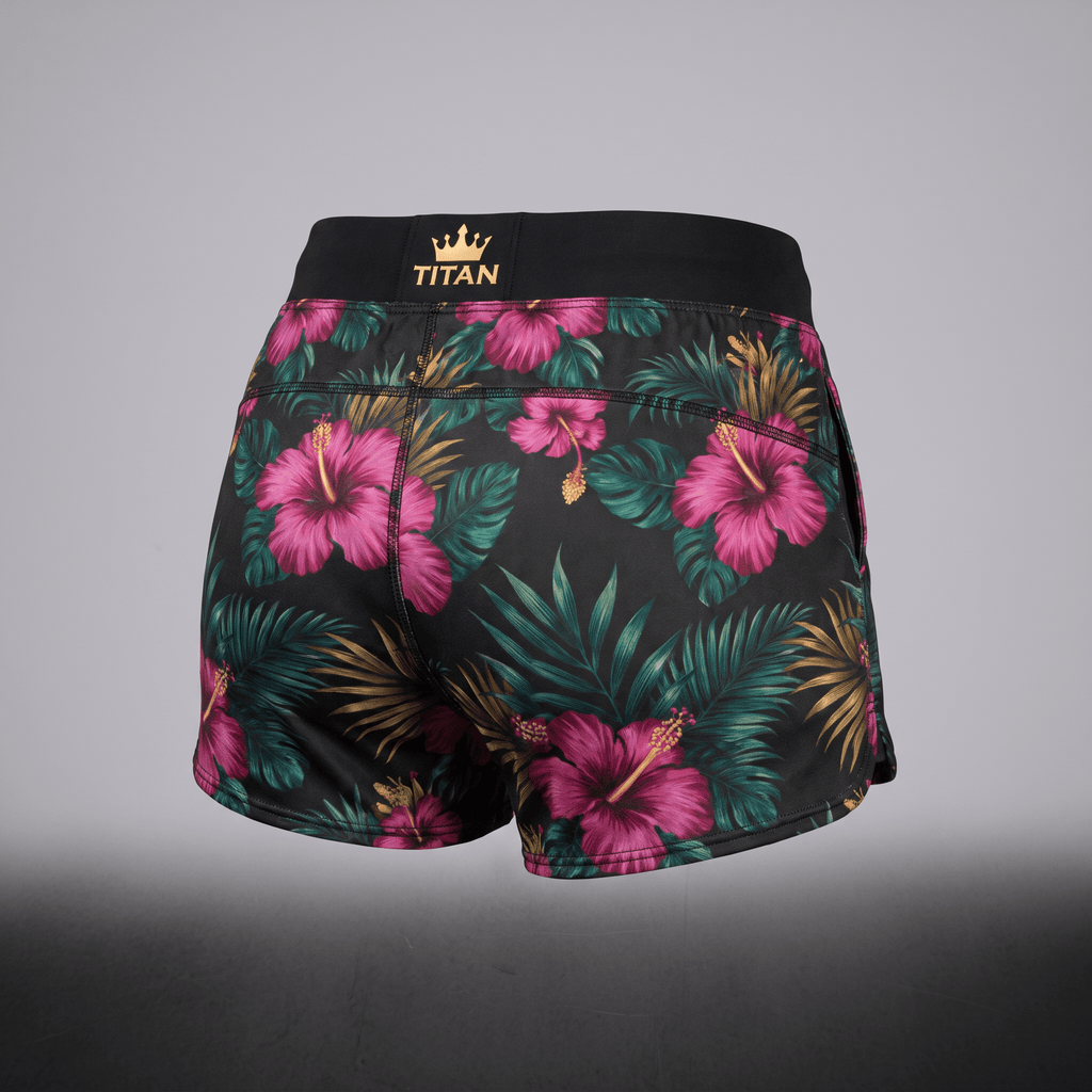 Back view of black athletic shorts with pink floral tropical print and gold Titan crown logo waistband.