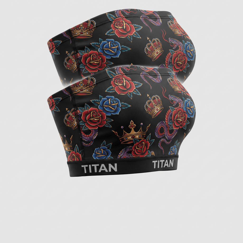Two Titan black sports bras featuring a traditional tattoo print of red and blue roses, crowns, and snakes.