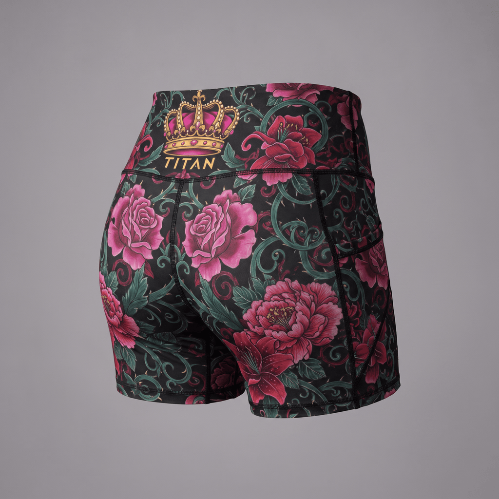 Black athletic shorts featuring a pink rose and green vine floral print with a gold Titan crown logo on the back.