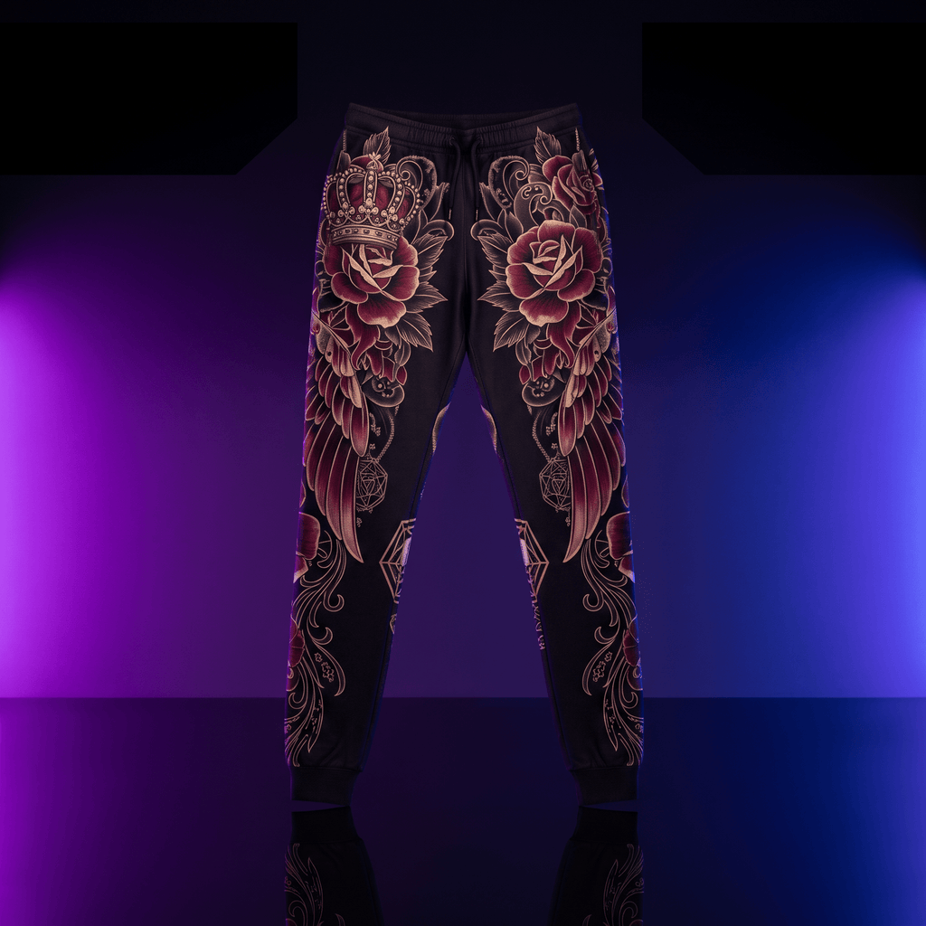 Black joggers featuring ornate gold and maroon rose, crown, and wing graphic prints against a purple-blue neon background.