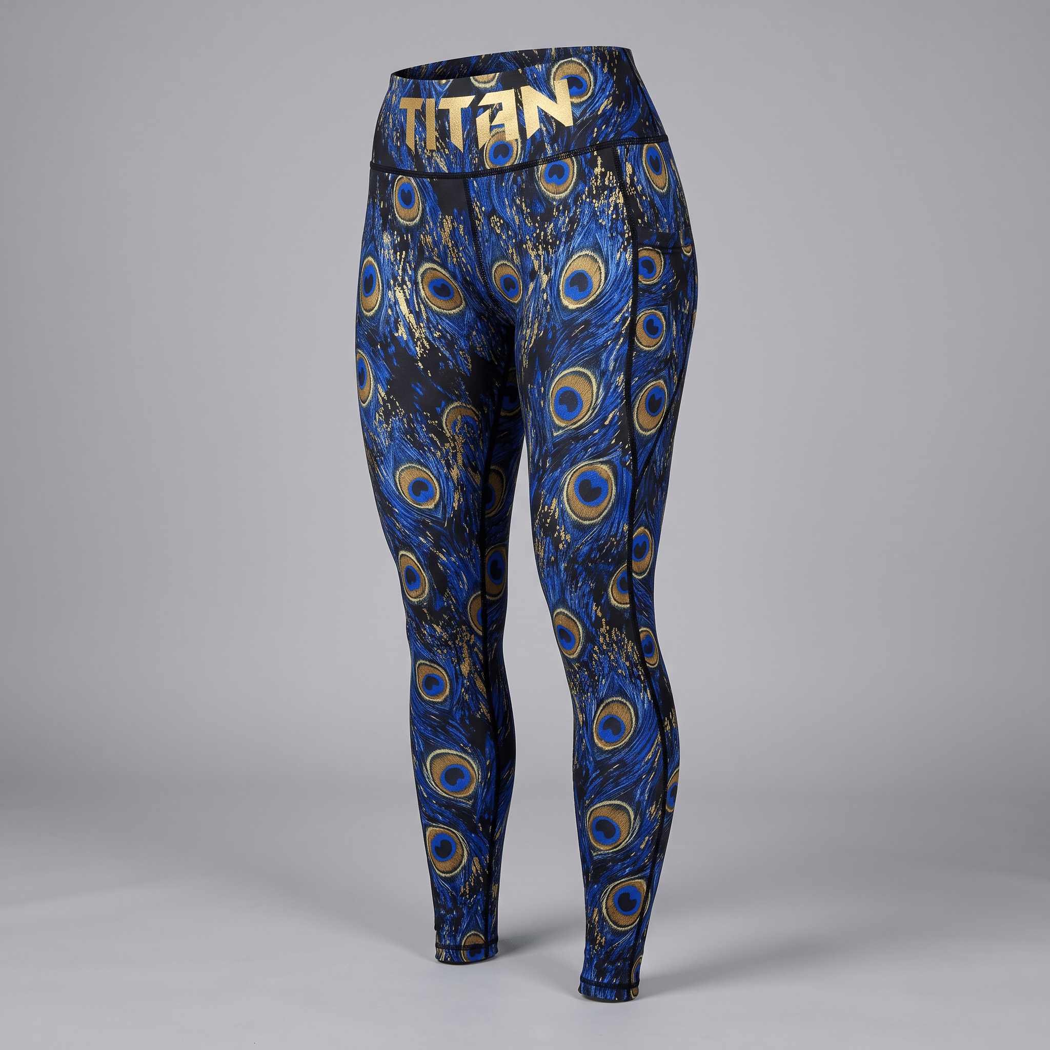 Blue and gold peacock feather print athletic leggings with Titan logo waistband.