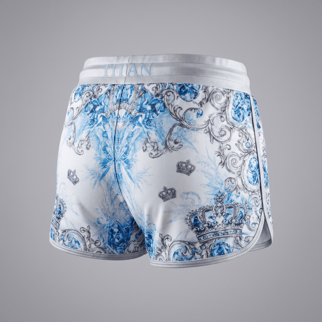Back view of white athletic shorts featuring a blue and silver baroque crown and gemstone print with Titan branding.
