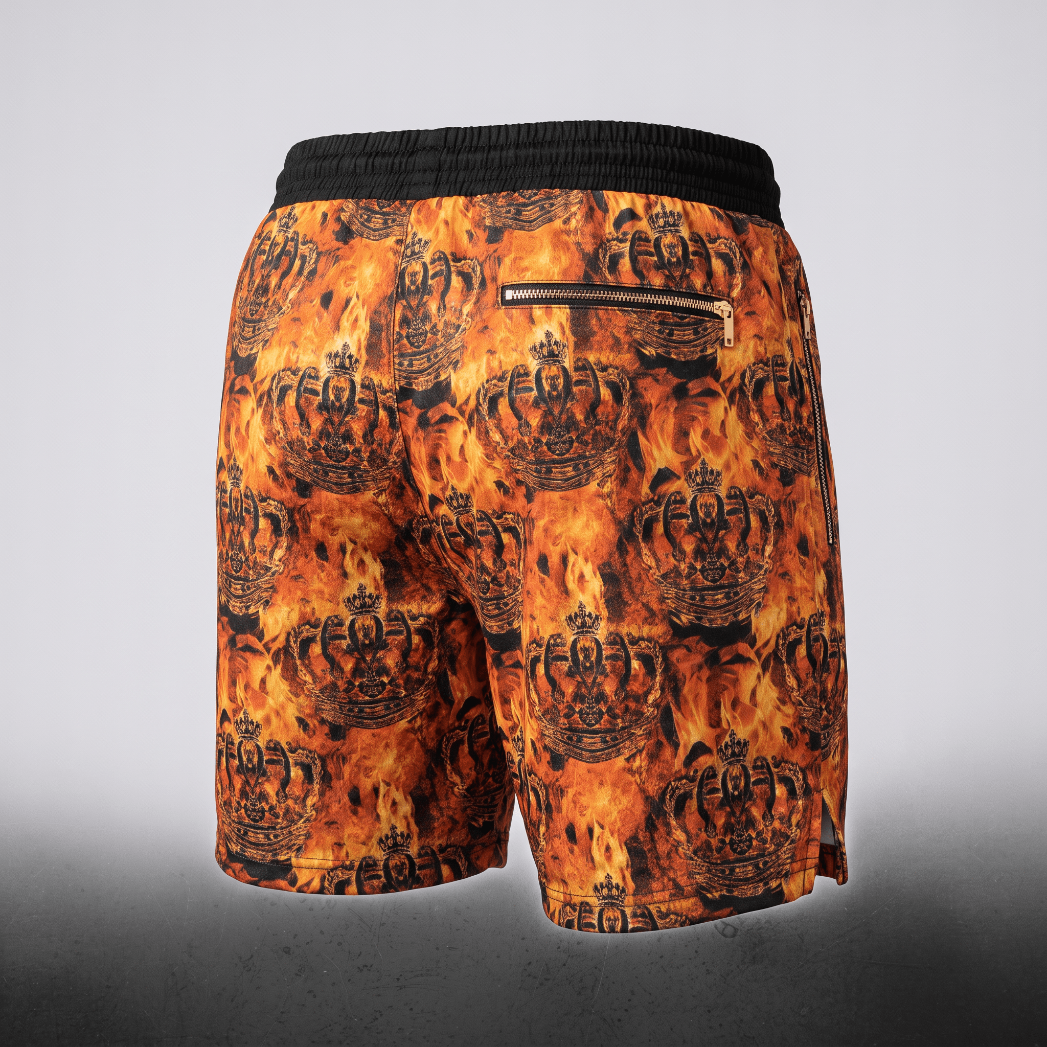 Back view of orange and black fire and crown print swim shorts with a black waistband and back zippered pocket.