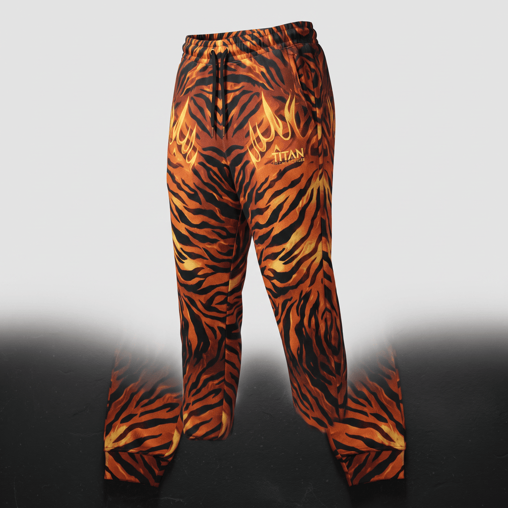 Orange and black tiger stripe sweatpants with a flame graphic and Titan logo on a neutral background.