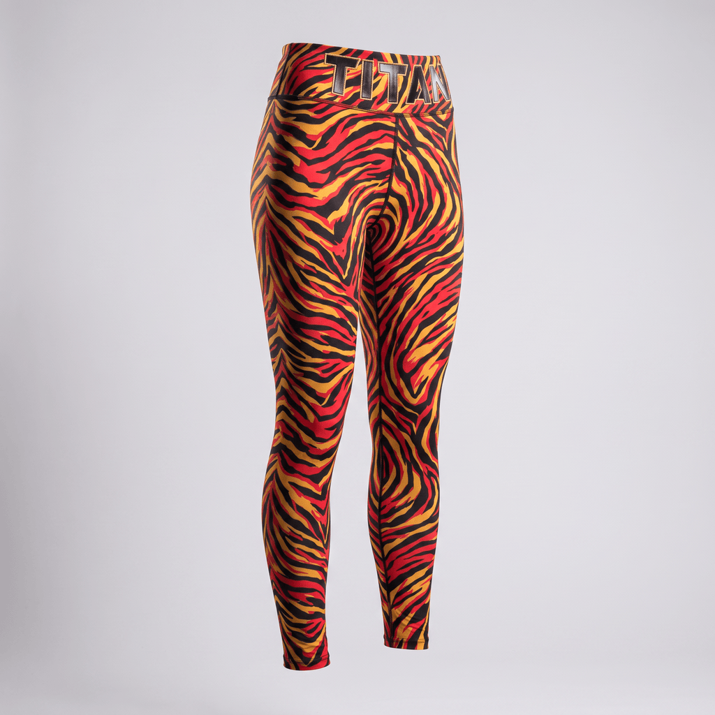 Red, yellow, and black animal print athletic leggings with Titan branded waistband on white.