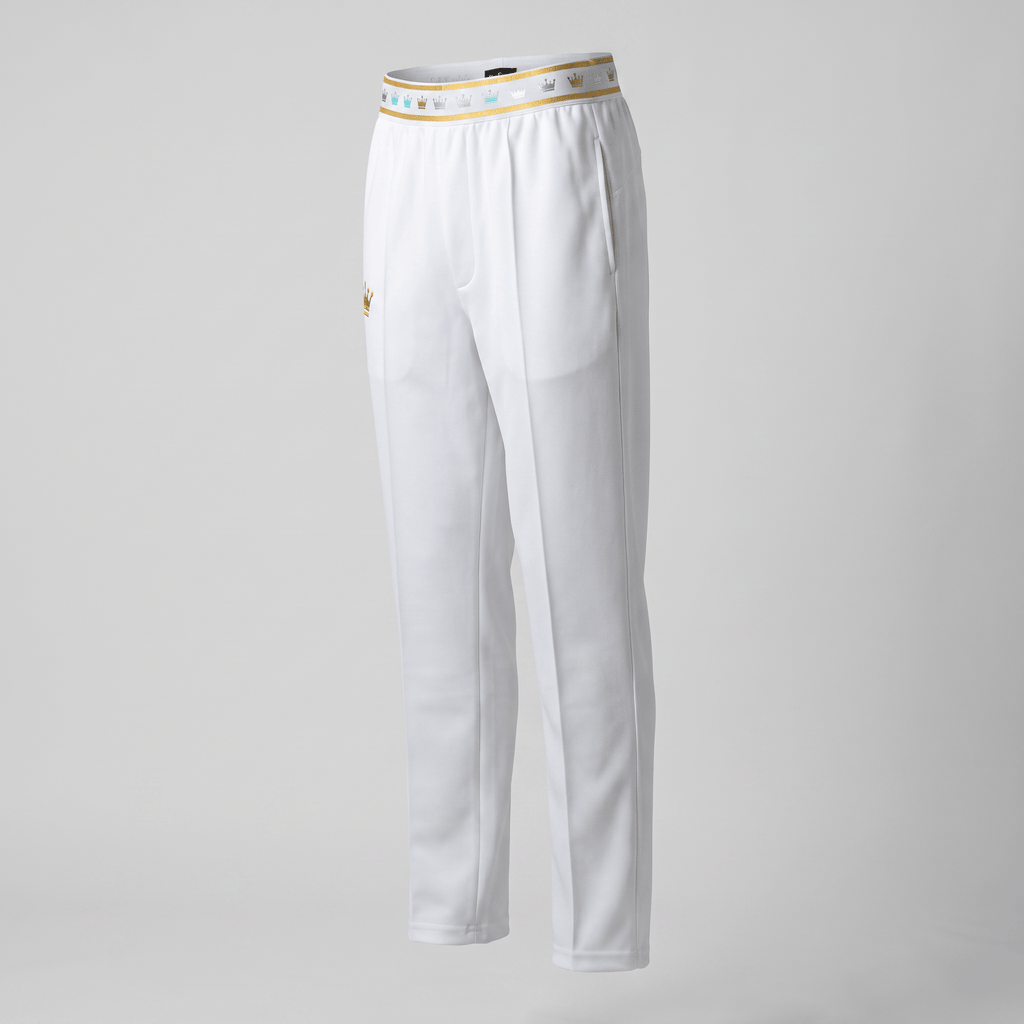 White athletic pants with a gold crown waistband and embroidered crown on the hip against a neutral background.