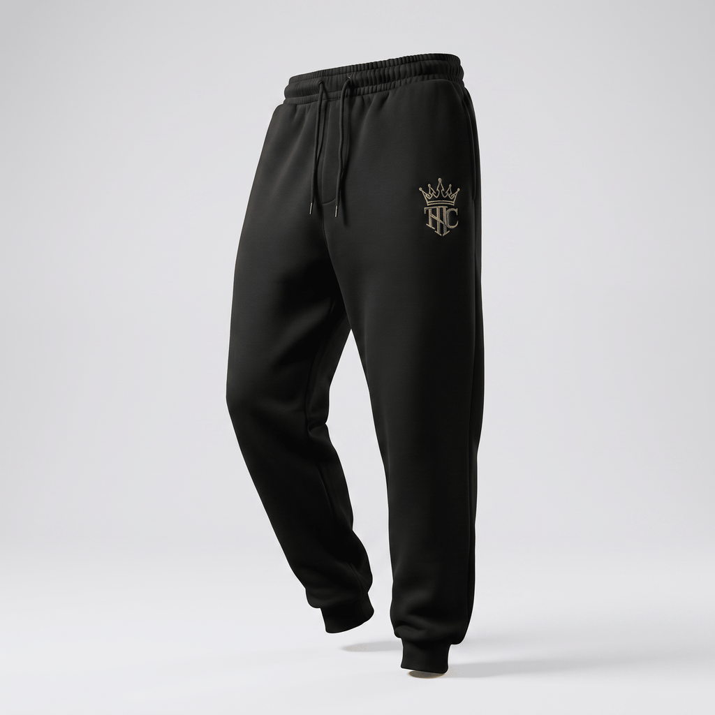 Black athletic sweatpants with an elastic drawstring waist and a metallic gold crown logo on the left hip.