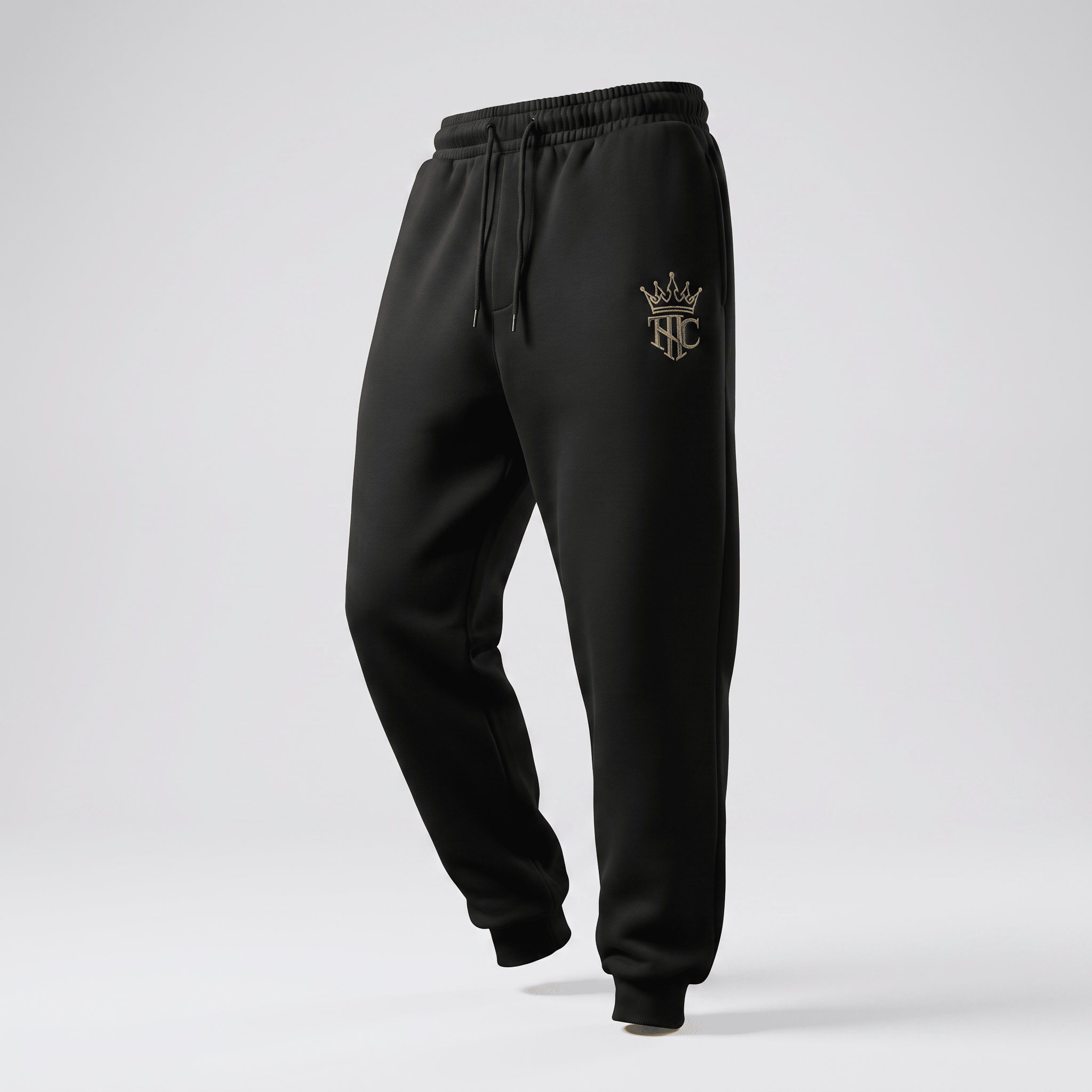 Black athletic sweatpants with an elastic drawstring waist and a metallic gold crown logo on the left hip.