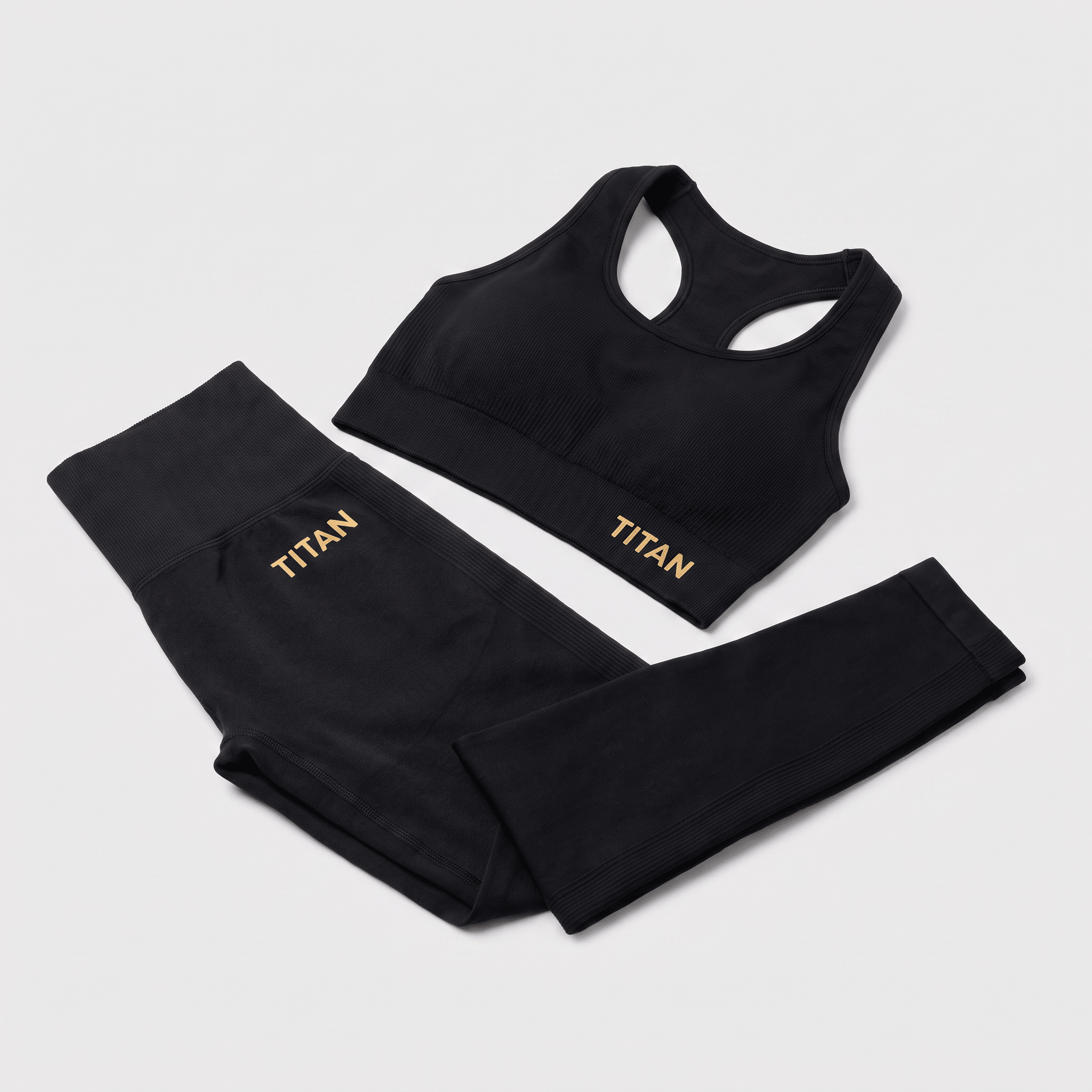 Black ribbed workout set with sports bra and high-waisted leggings featuring gold Titan logos.