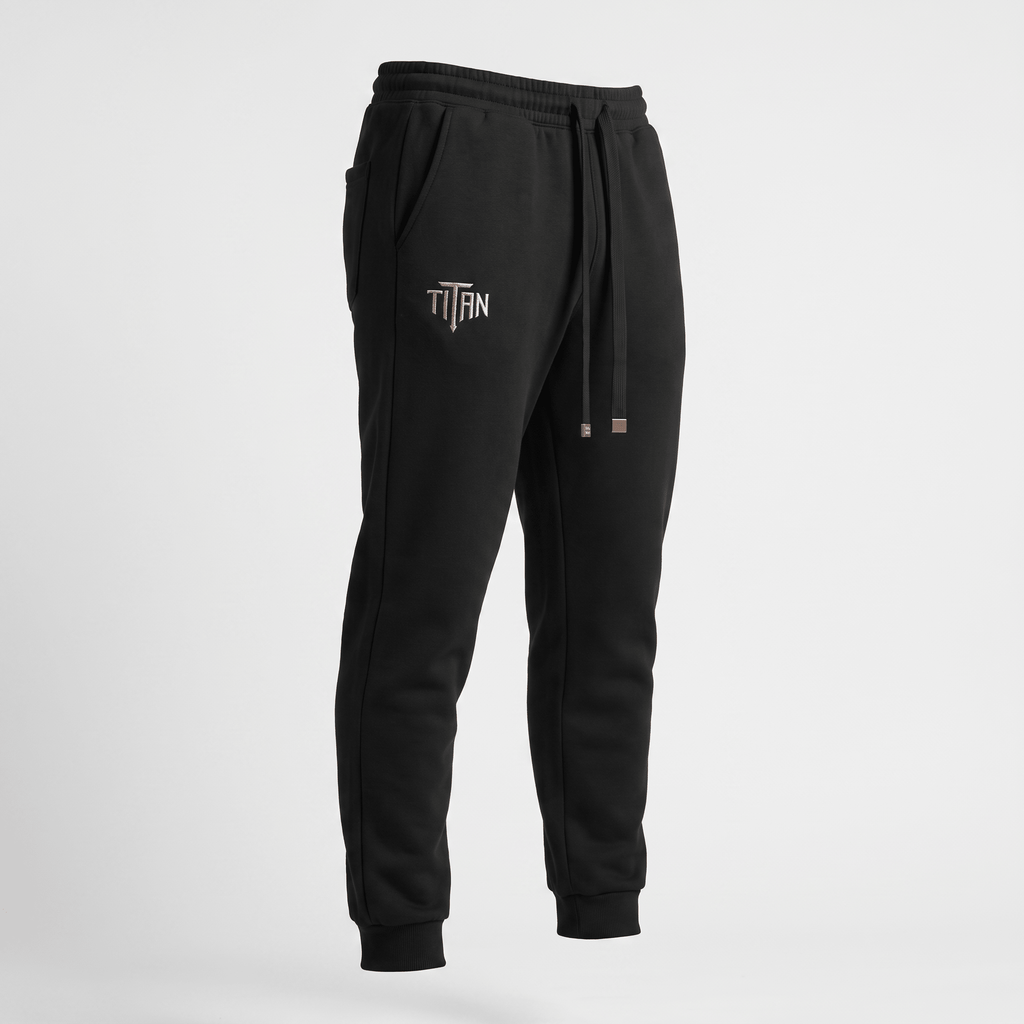 Black athletic sweatpants with cuffed ankles, drawstring waist, and Titan logo on the right hip.