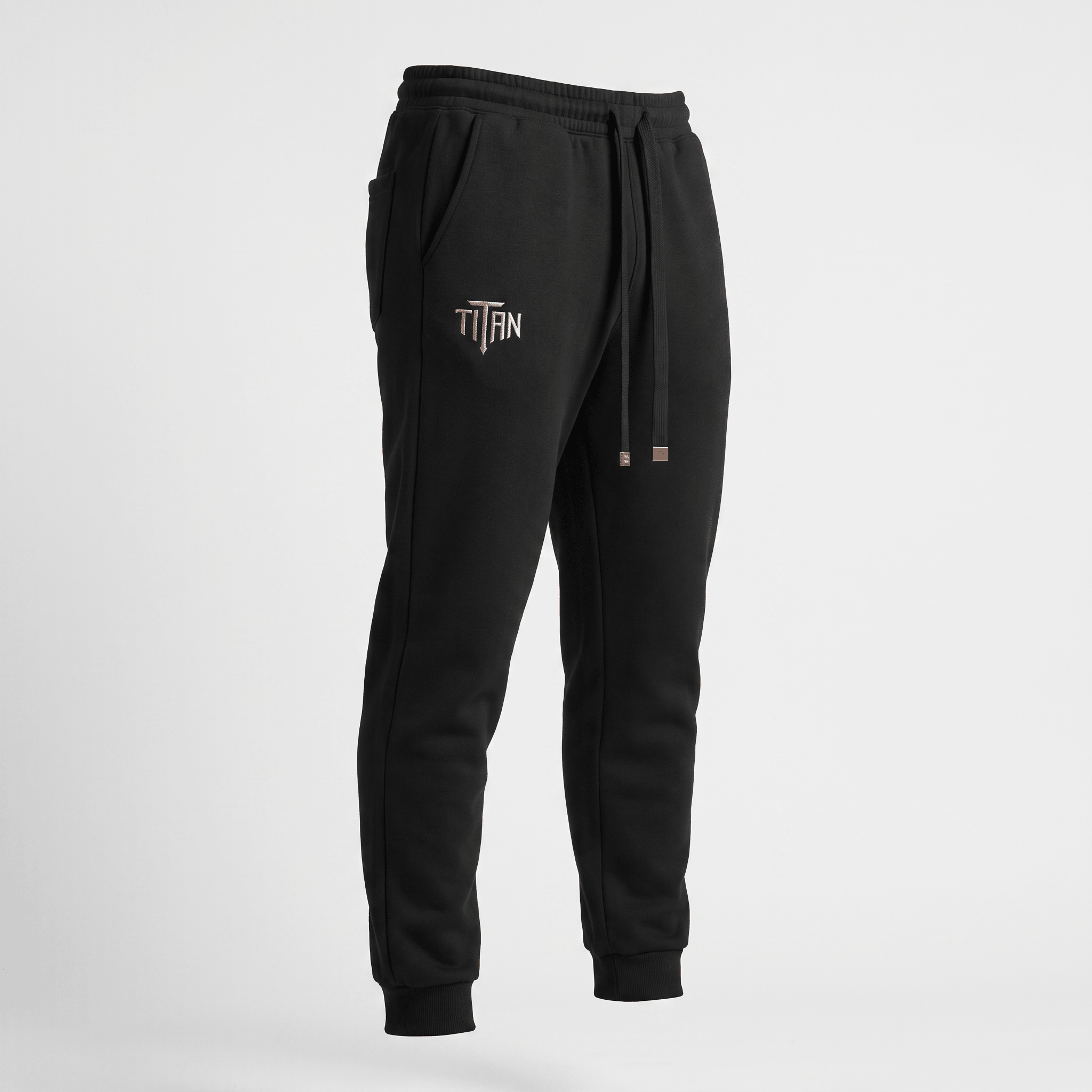 Black athletic sweatpants with cuffed ankles, drawstring waist, and Titan logo on the right hip.