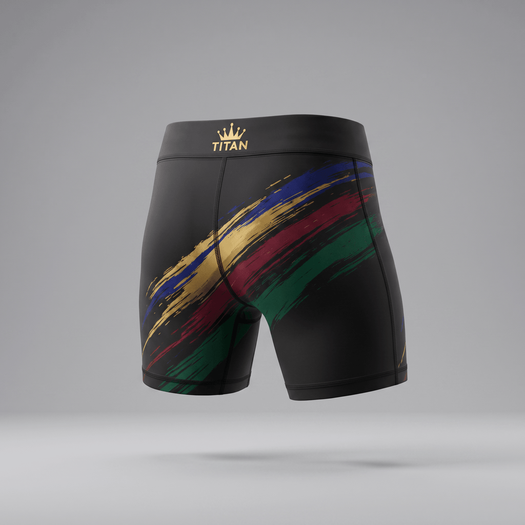 Rear view of black athletic compression shorts with a gold Titan crown logo and diagonal blue, gold, red, and green paint strokes.
