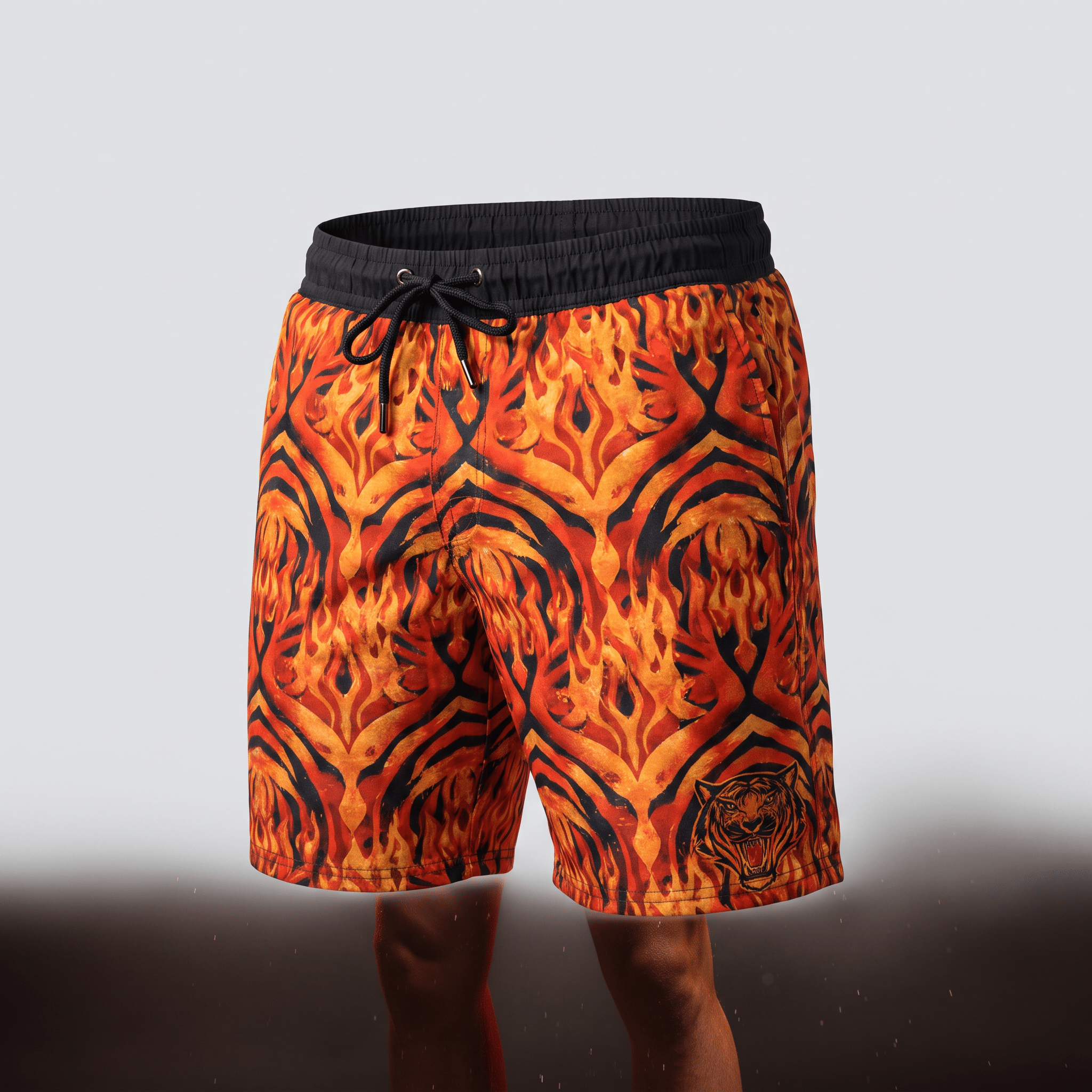 Orange and black swim shorts with a flame and tiger stripe pattern, black waistband, and drawstring.