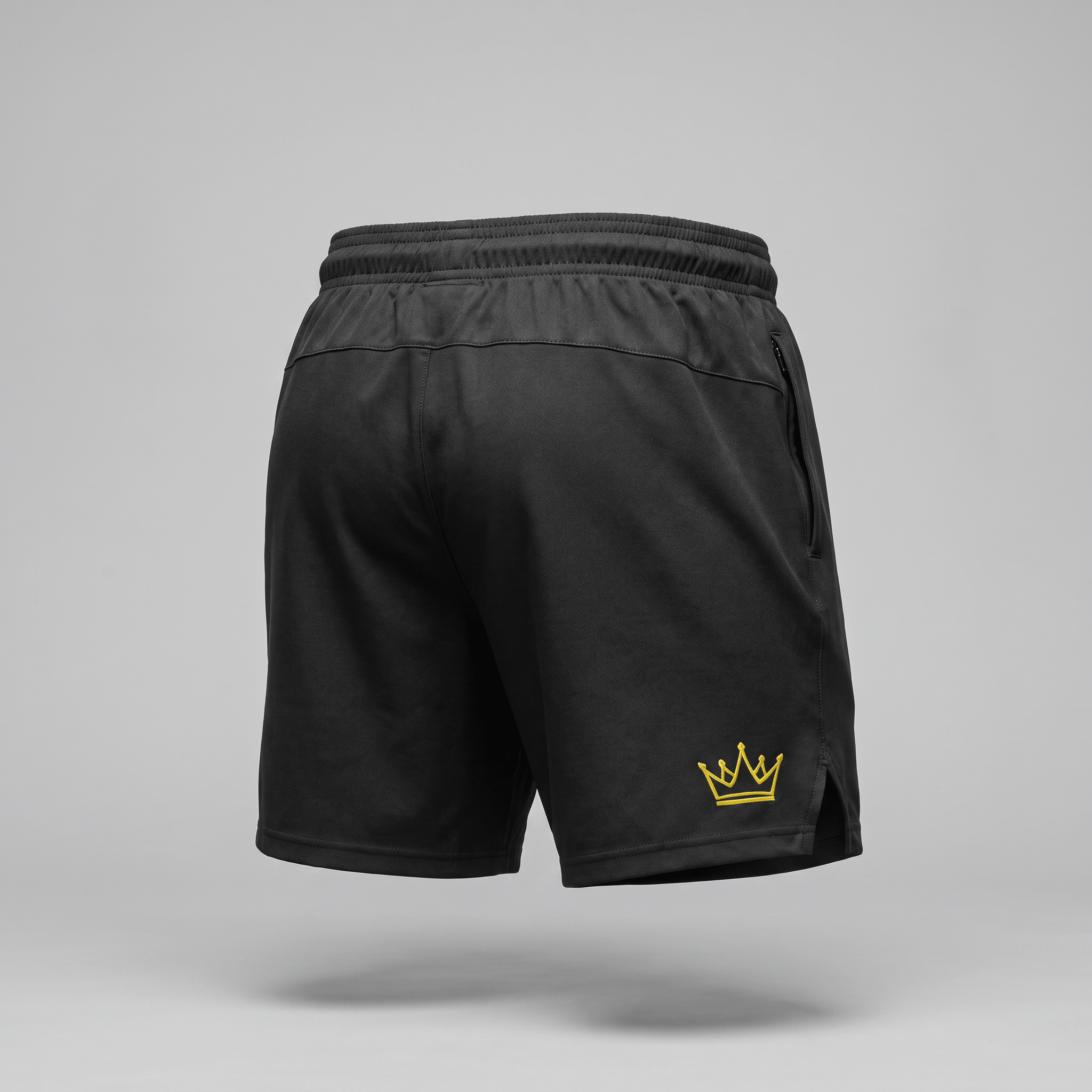 Back view of black athletic shorts with an elastic waistband, zipper pocket, and yellow crown logo.