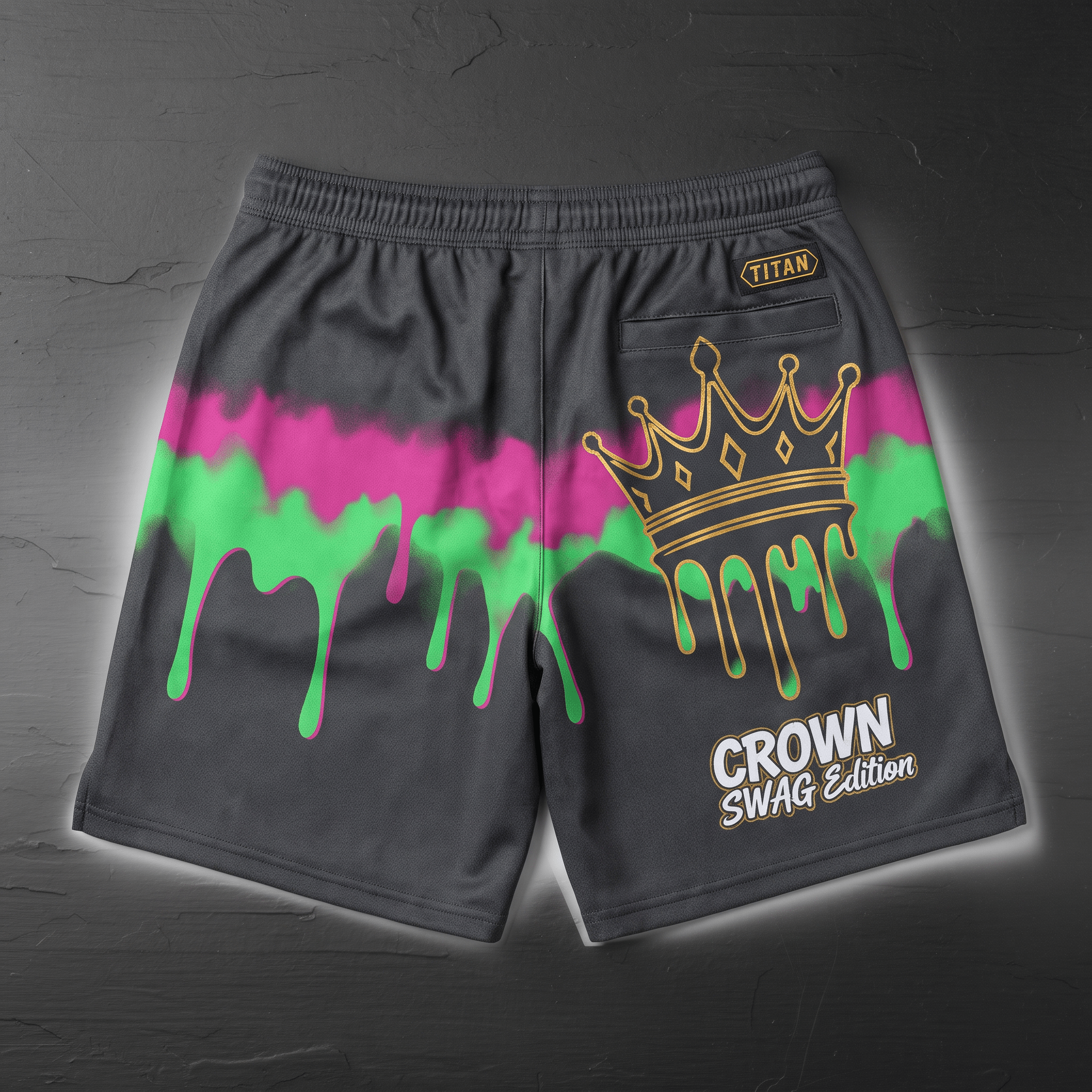 Back of dark grey athletic shorts with pink and green paint drip graphics, gold crown, and text.