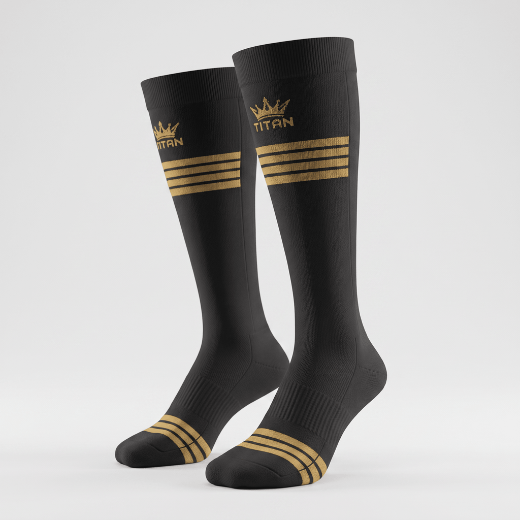 Black athletic crew socks with gold Titan crown logo and triple stripe design on a light gray background.
