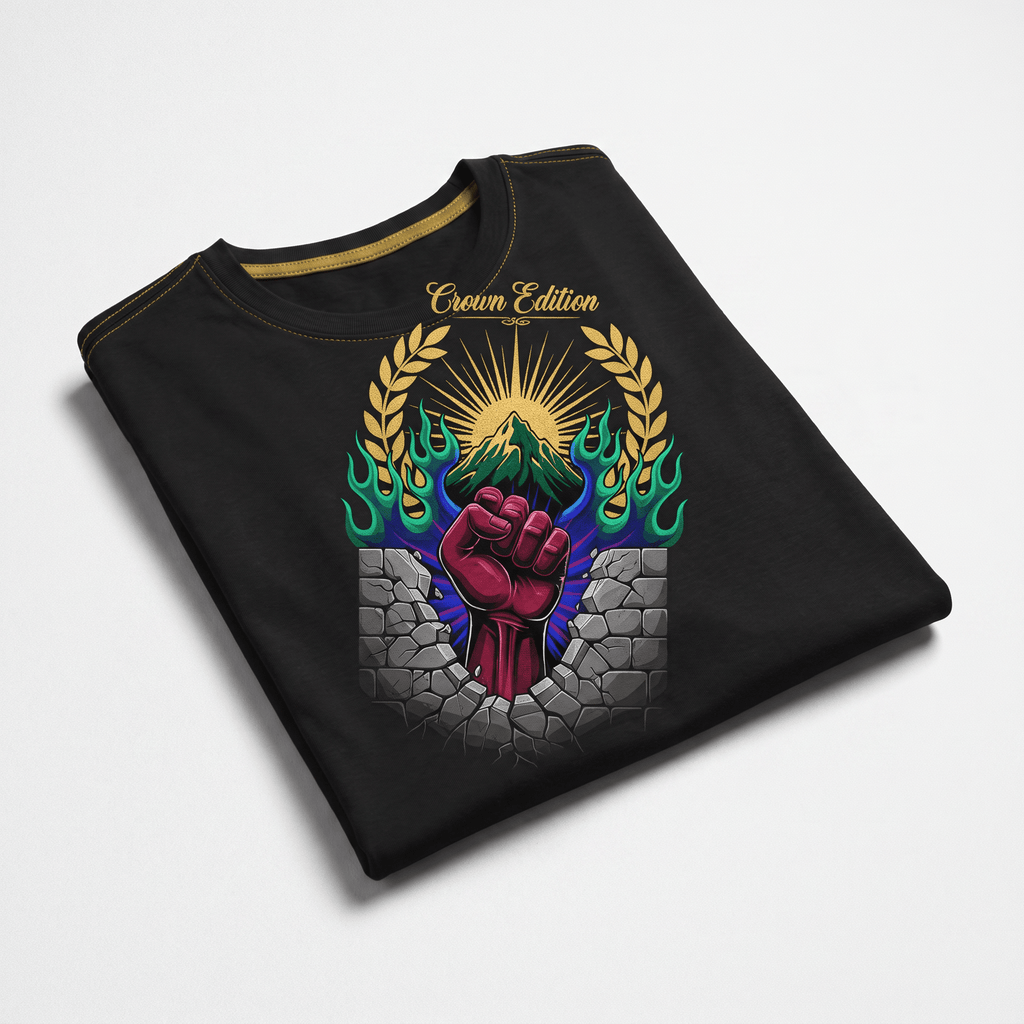 Folded black t-shirt with a graphic of a red fist breaking through a stone wall beneath a mountain and sun.