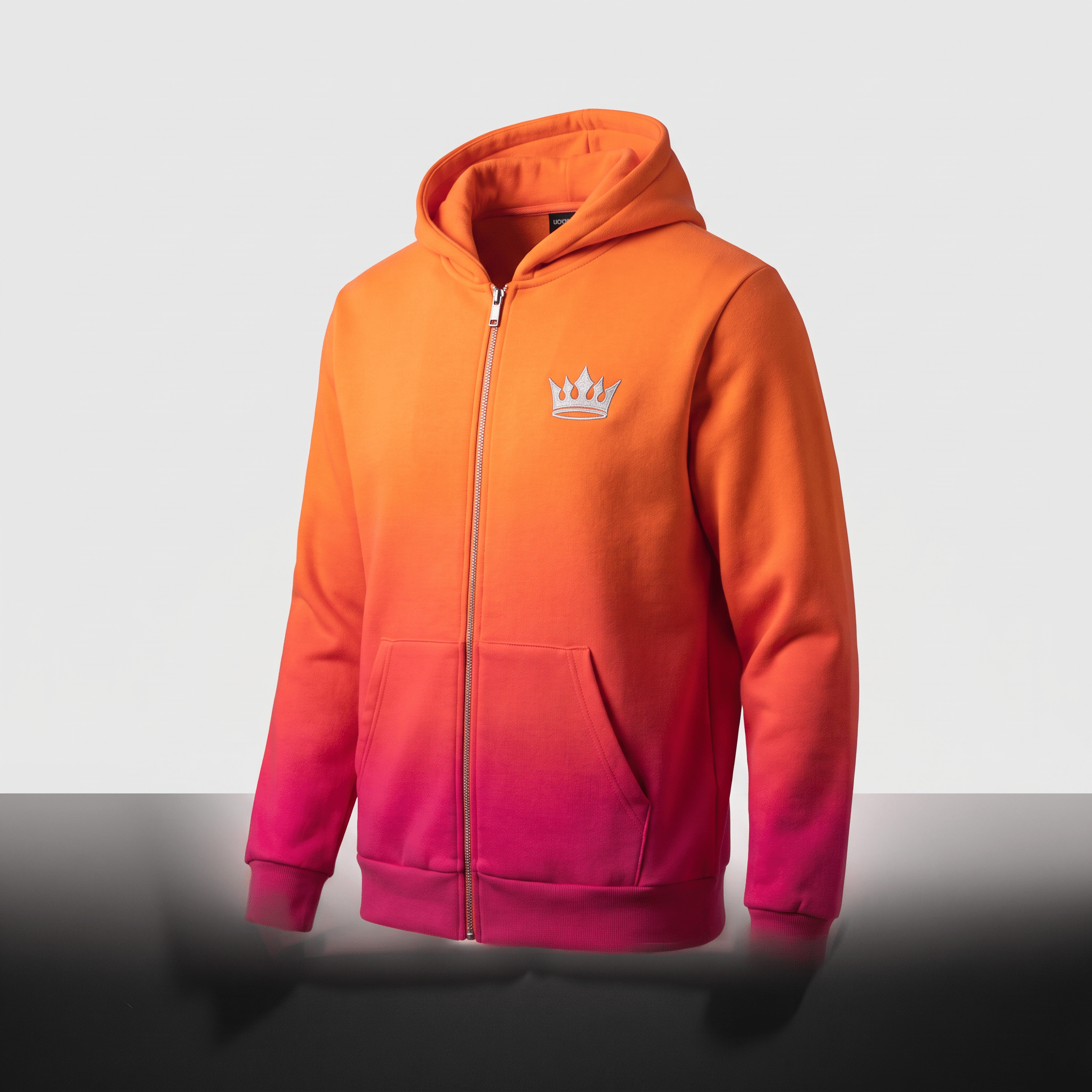 Orange and pink ombre full-zip hoodie with a silver crown logo on the chest and front pockets.
