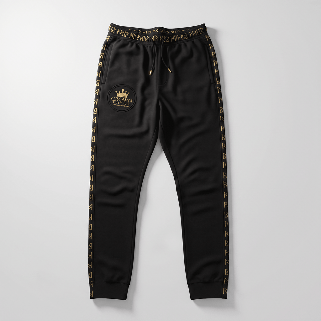 Black athletic joggers with gold side stripes, crown edition logo, and drawstring waistband on light gray.