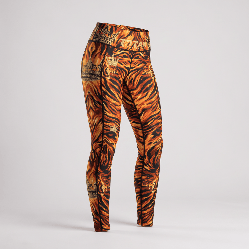 Orange and black tiger print high-waisted fitness leggings featuring gold crown graphics and Titan branding.