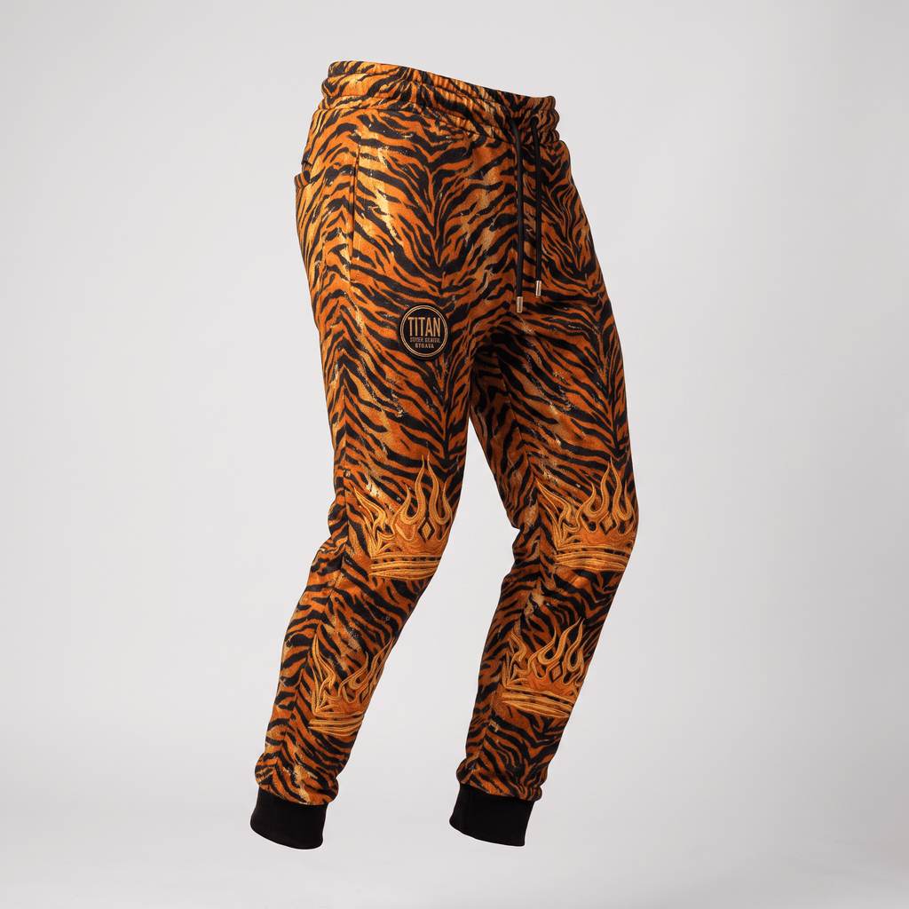 Orange and black tiger print joggers with black cuffs, drawstring waist, and gold crown graphics.
