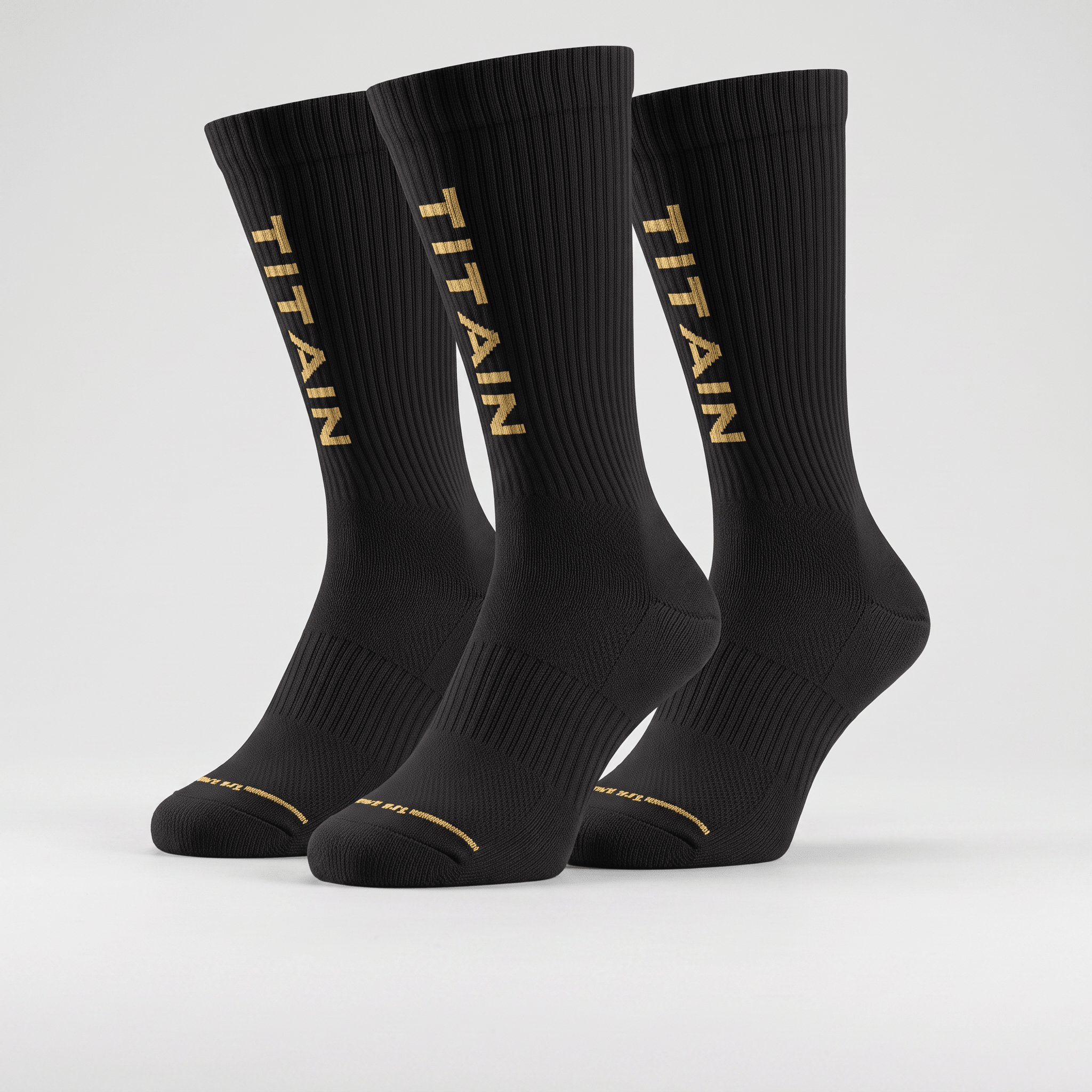 Three black crew socks with gold TITAIN logo lettering down the side on a light grey background.