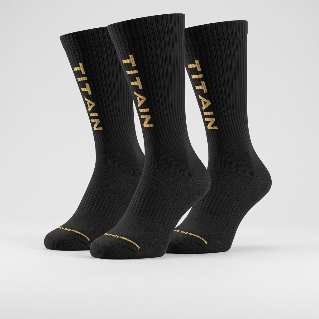 Three black crew socks with gold TITAIN logo text on a light gray background.
