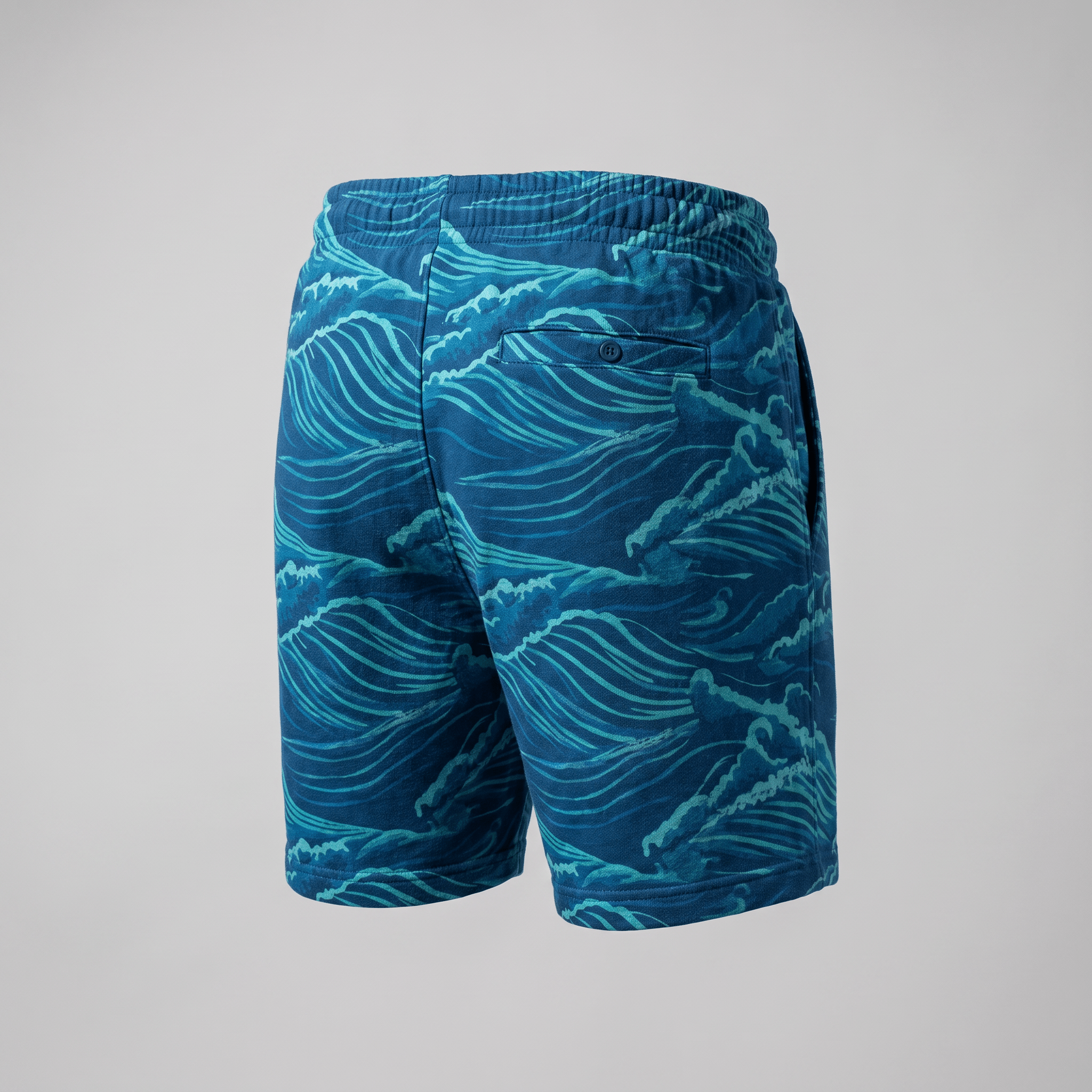Back view of blue casual shorts with an ocean wave print, elastic waistband, and a single back pocket.