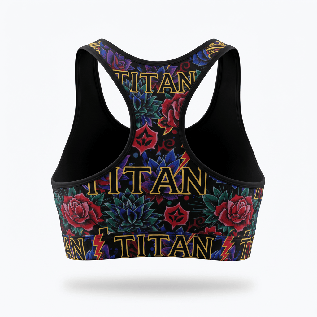 Back view of a black racerback sports bra featuring a tattoo print with red roses, blue flowers, and gold Titan text.