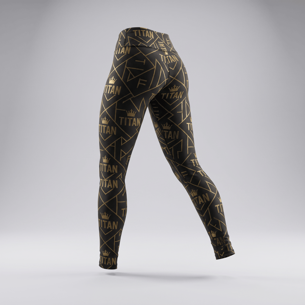 Black and gold Titan print athletic leggings viewed from the back against a gray background.