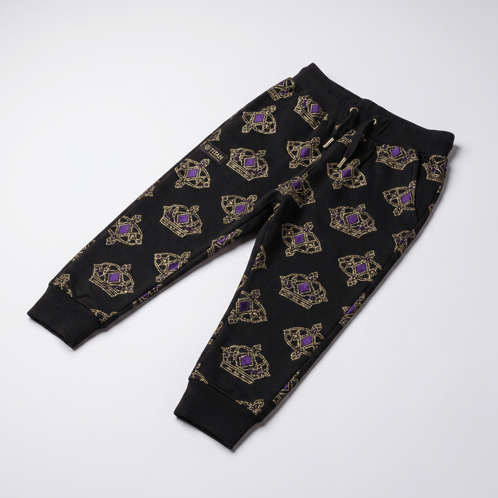 Black sweatpants with gold and purple crown pattern, elastic waistband, and cuffed ankles laid flat.
