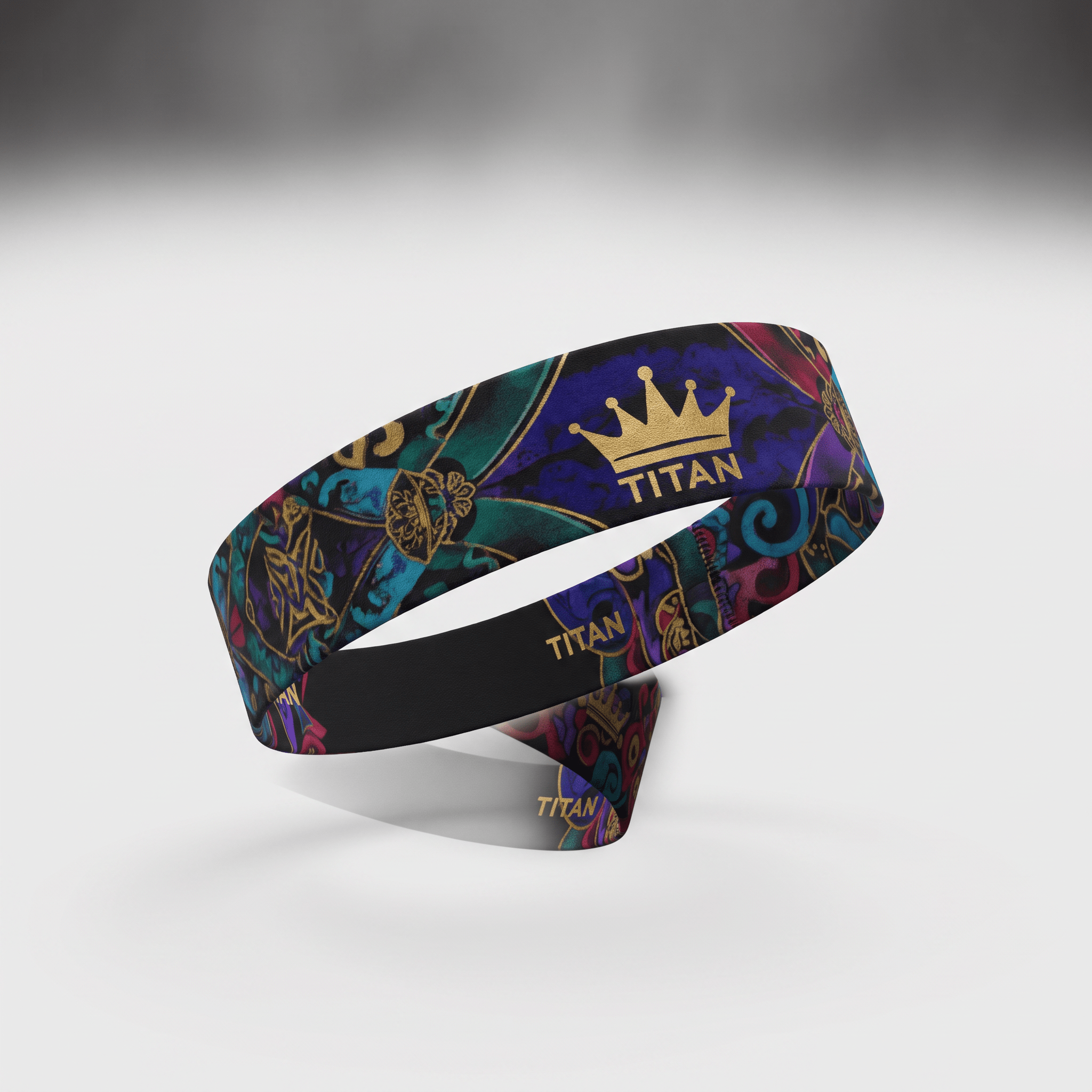 Titan athletic headband in blue, teal, and gold with a baroque crown pattern on white background.