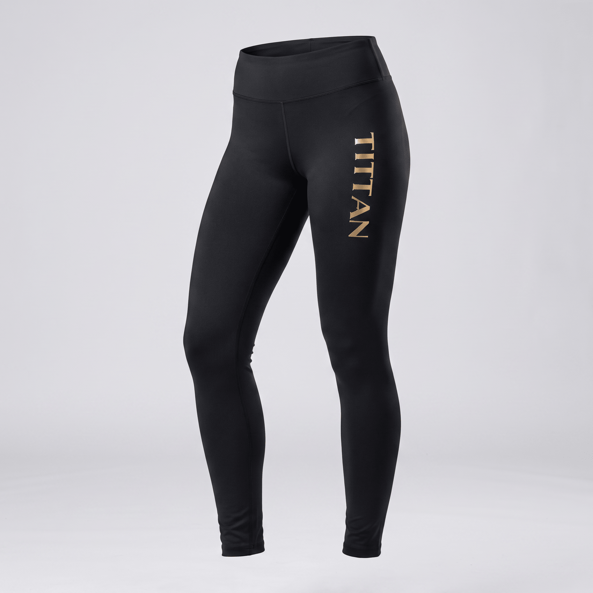 Black athletic leggings with high waist and gold Tittan logo on left leg against plain background