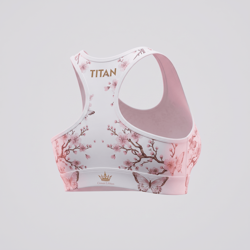 Pink sports bra featuring a cherry blossom and butterfly pattern with gold Titan branding on the back.