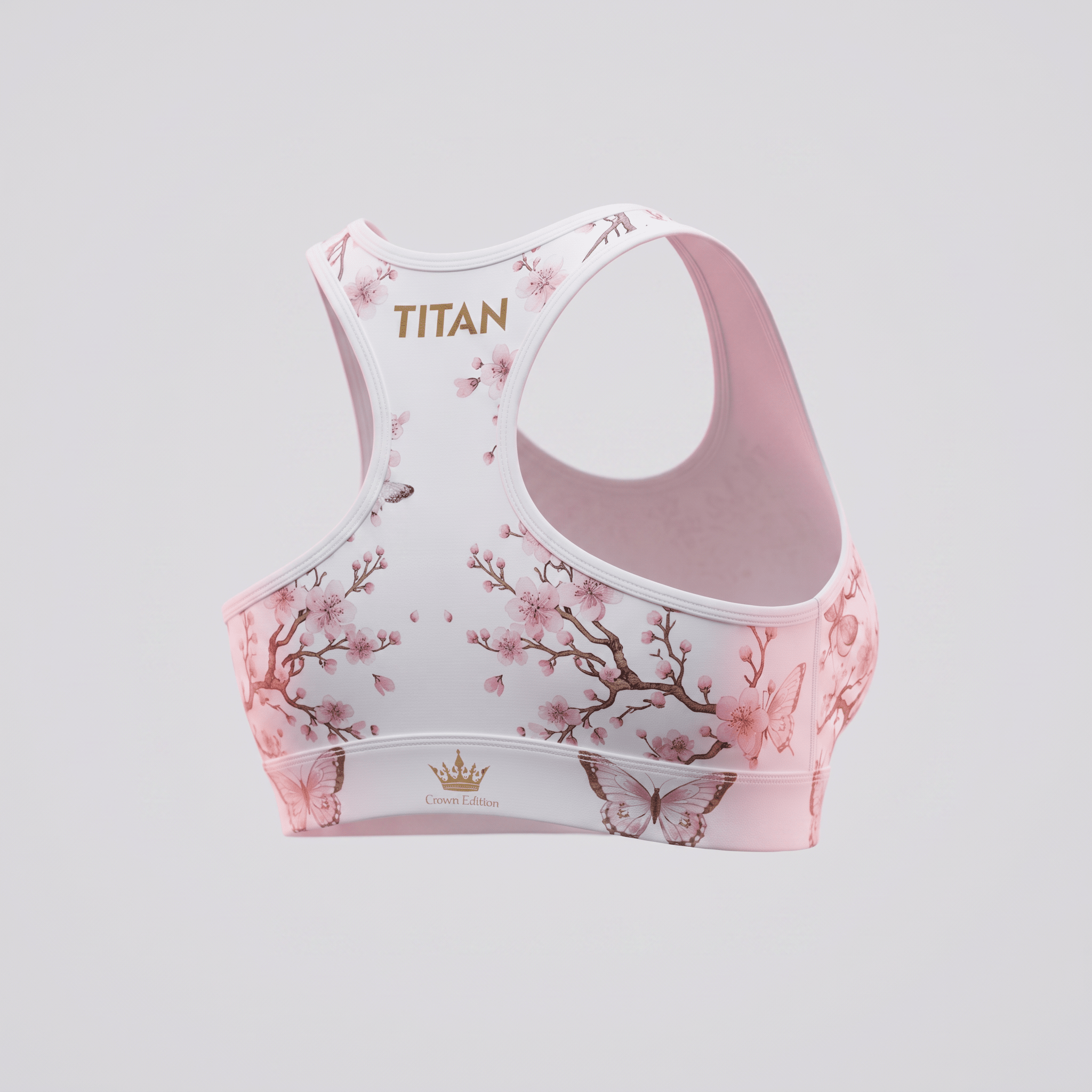 Pink sports bra featuring a cherry blossom and butterfly print with gold Titan and Crown Edition branding.