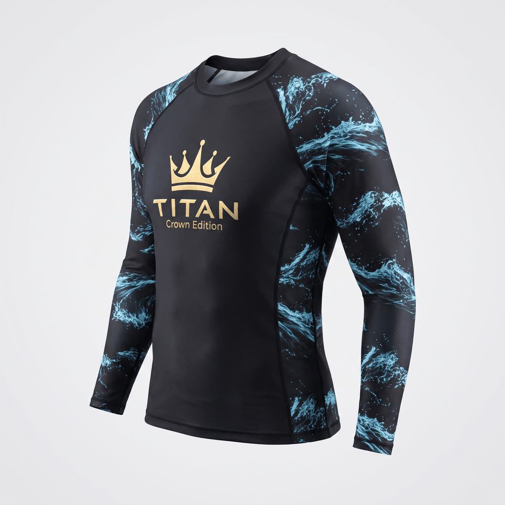 Black long-sleeve rash guard with blue ocean wave sleeves and gold Titan Crown Edition logo on the chest.