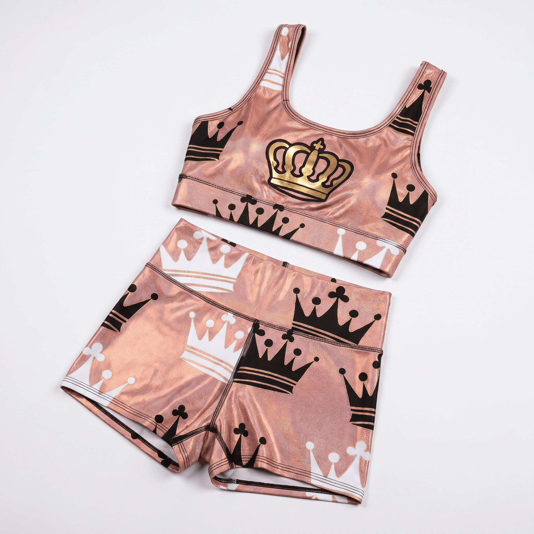 Metallic pink athletic crop top and shorts set featuring black, white, and gold crown prints.