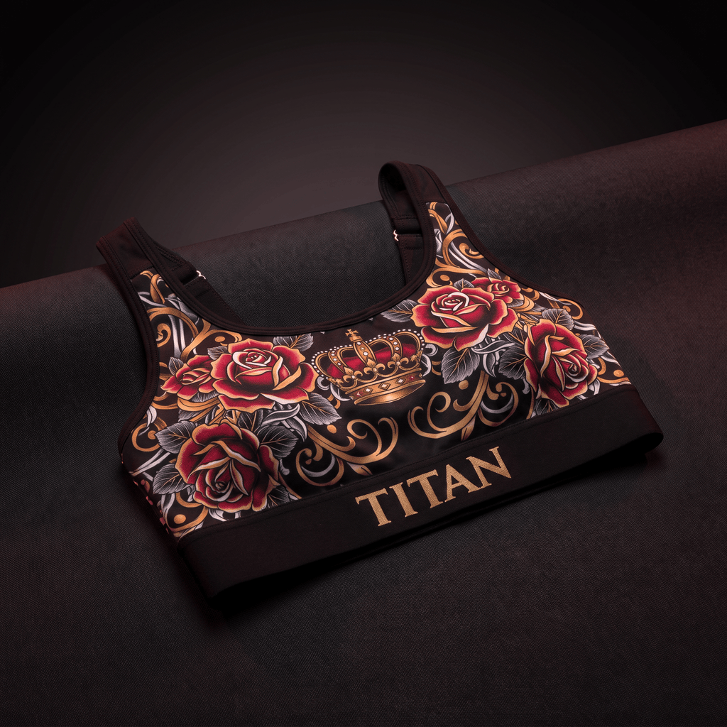 Black sports bra with gold TITAN logo, featuring a red rose and gold crown print on a dark background.