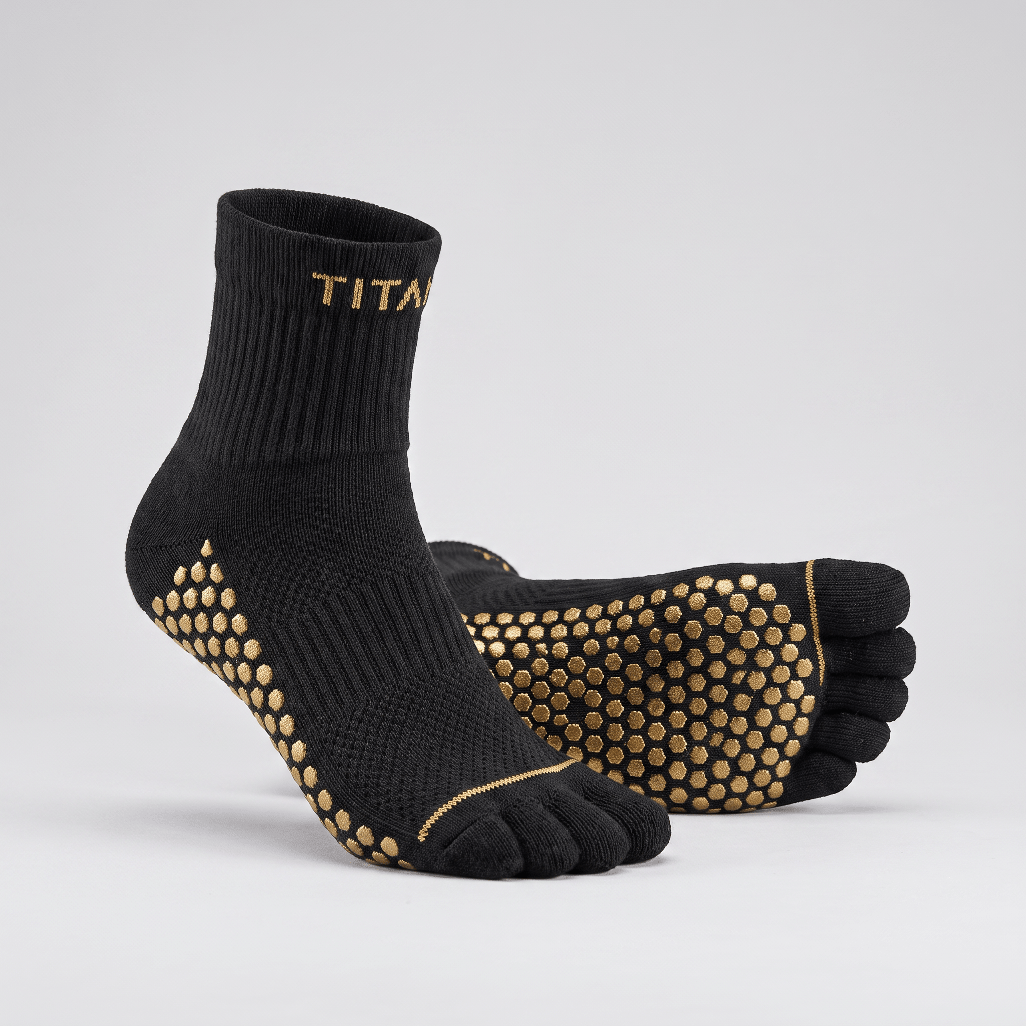 Black toe socks with gold grip dots on the sole and heel, plus gold branding on the cuff.