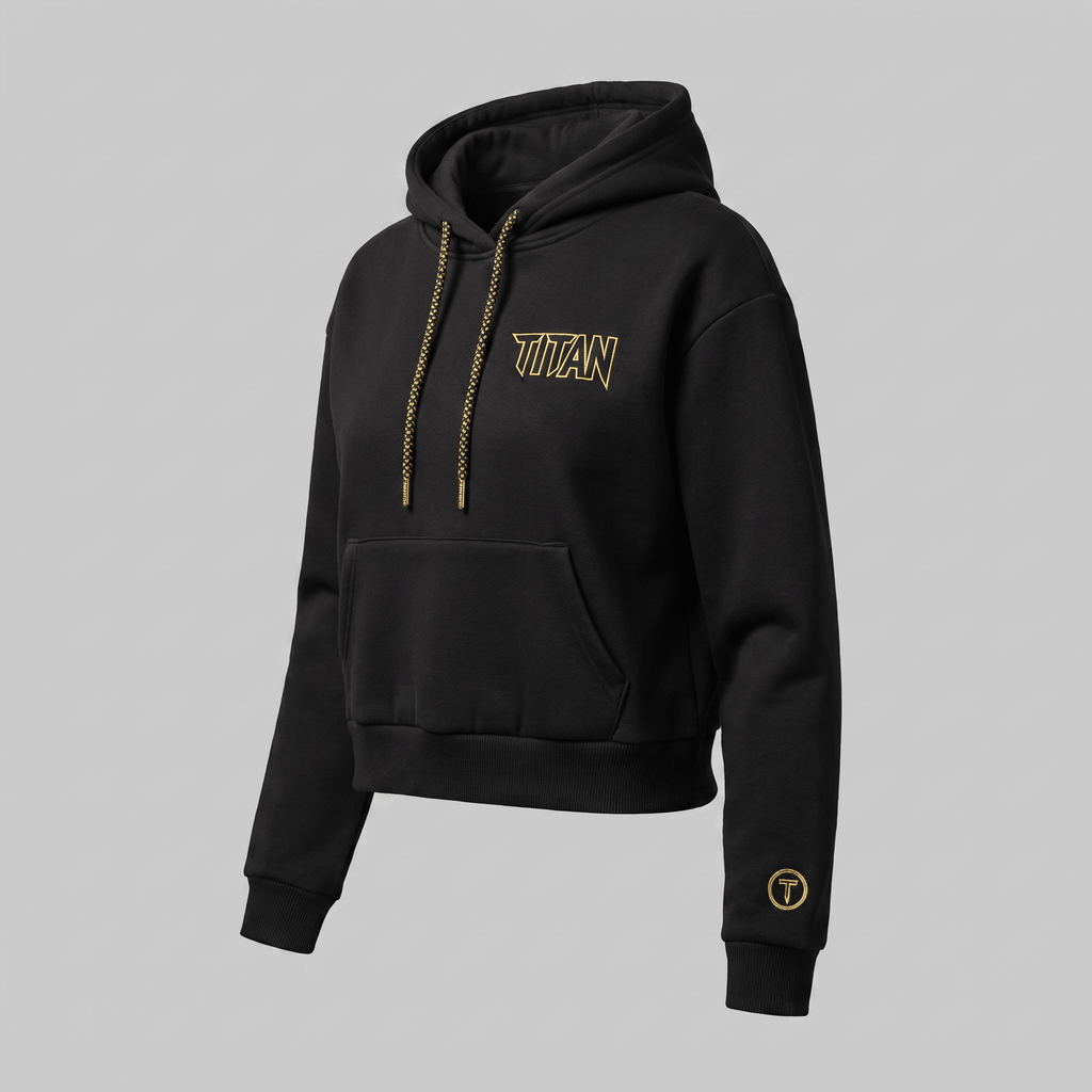 Black crop hoodie with gold Titan logo and patterned drawstrings on grey background.
