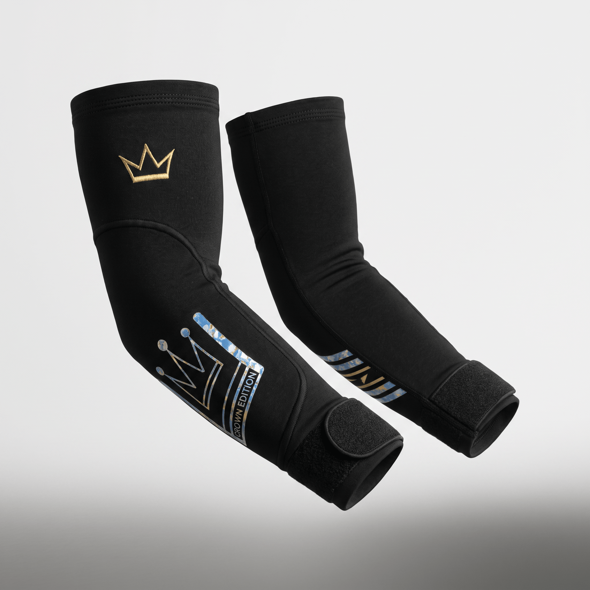 Pair of black elbow sleeves with gold crown logo and blue camouflage crown edition text.