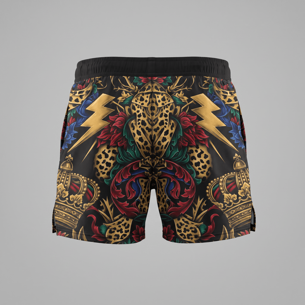 Black athletic shorts featuring a bold baroque tattoo print with gold crowns, lightning bolts, and floral patterns.