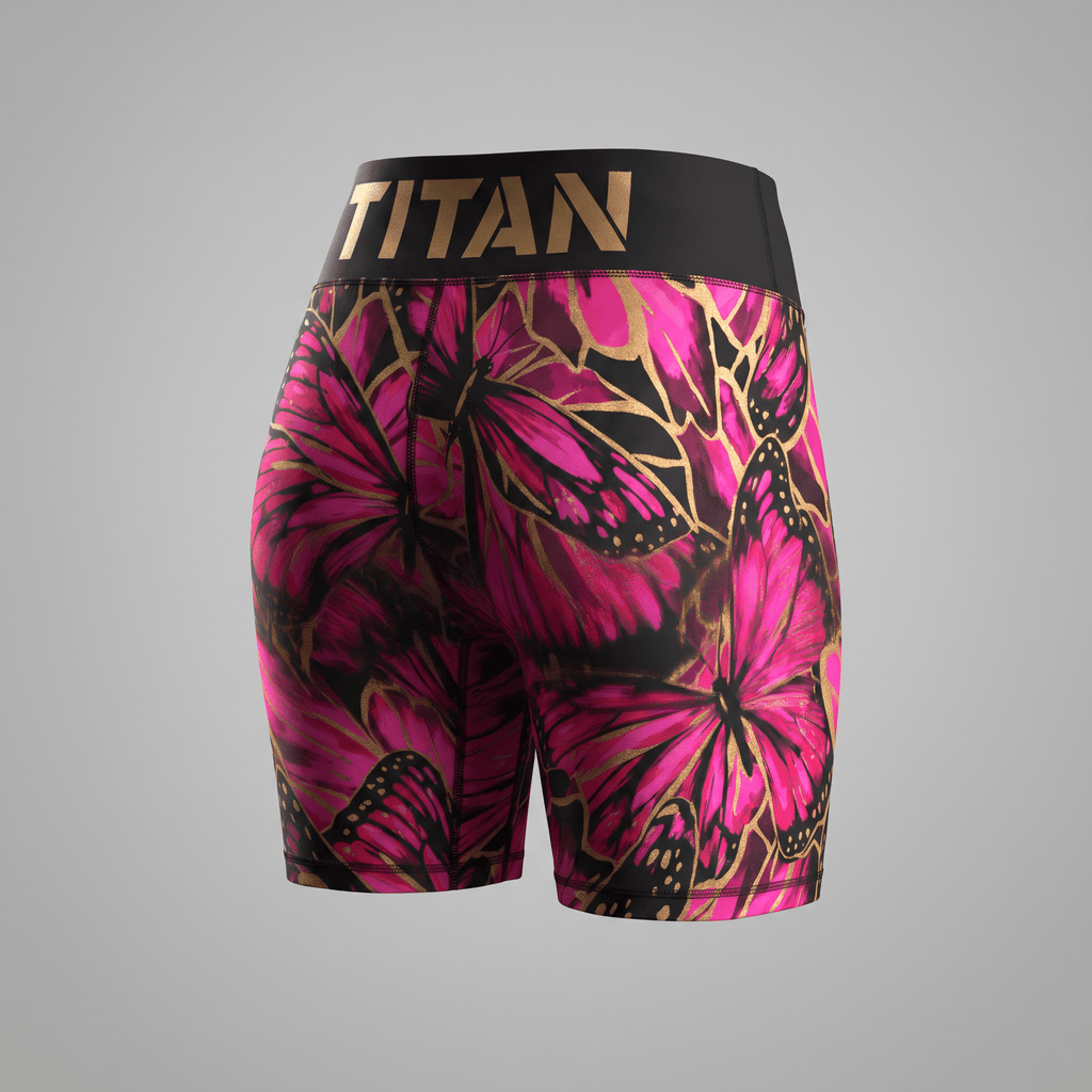 Back view of black athletic shorts featuring a pink and gold butterfly print and a wide Titan waistband.