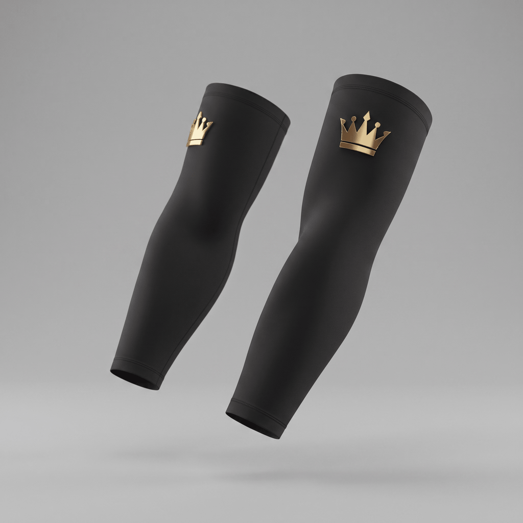 Black athletic arm sleeves featuring a gold crown logo against a grey background.