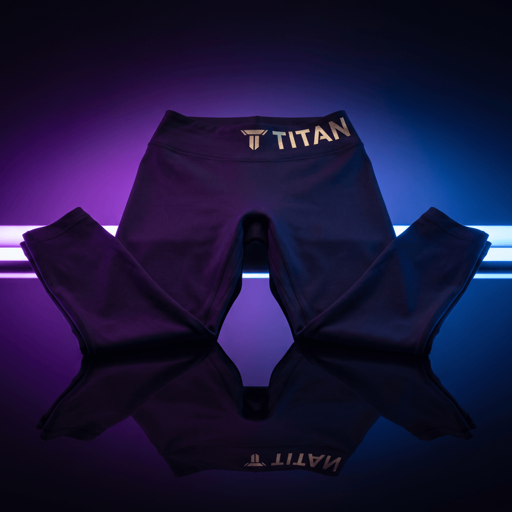 Black athletic leggings with gold "TITAN" branding on the waistband, set against neon purple and blue backlighting.