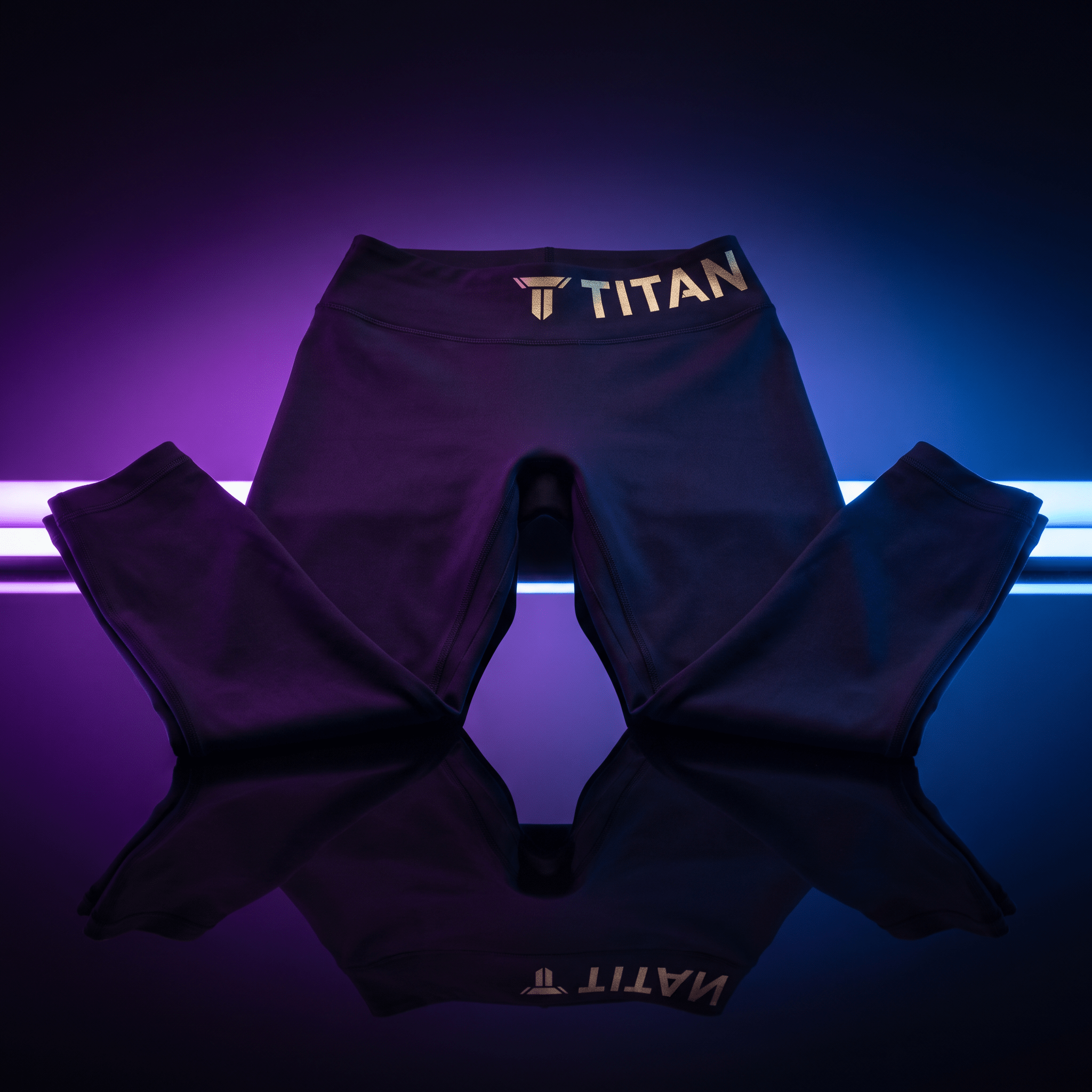 Black athletic leggings with gold "TITAN" branding on the waistband, set against neon purple and blue backlighting.