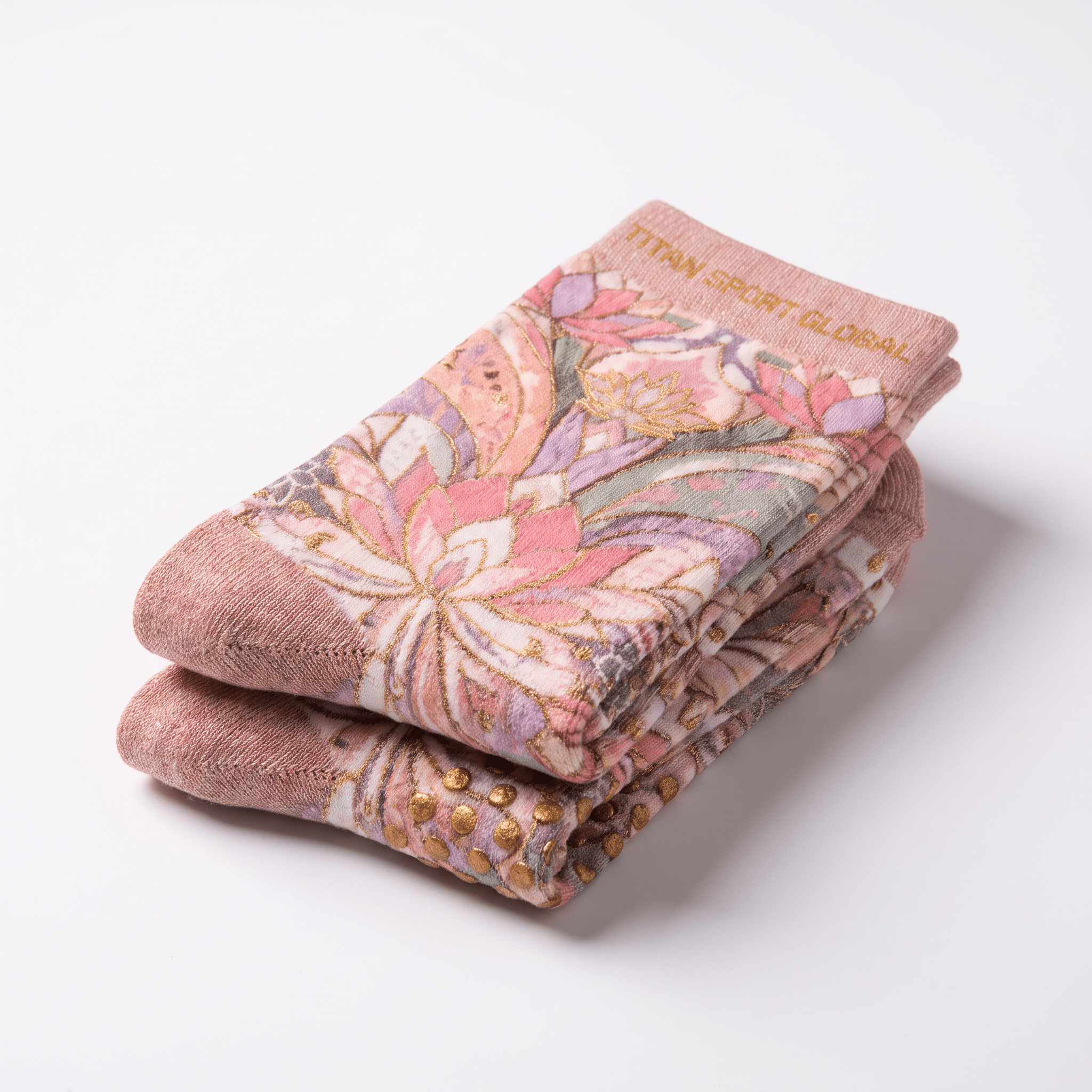 Folded pink crew socks with floral pattern and gold grip dots on the sole.