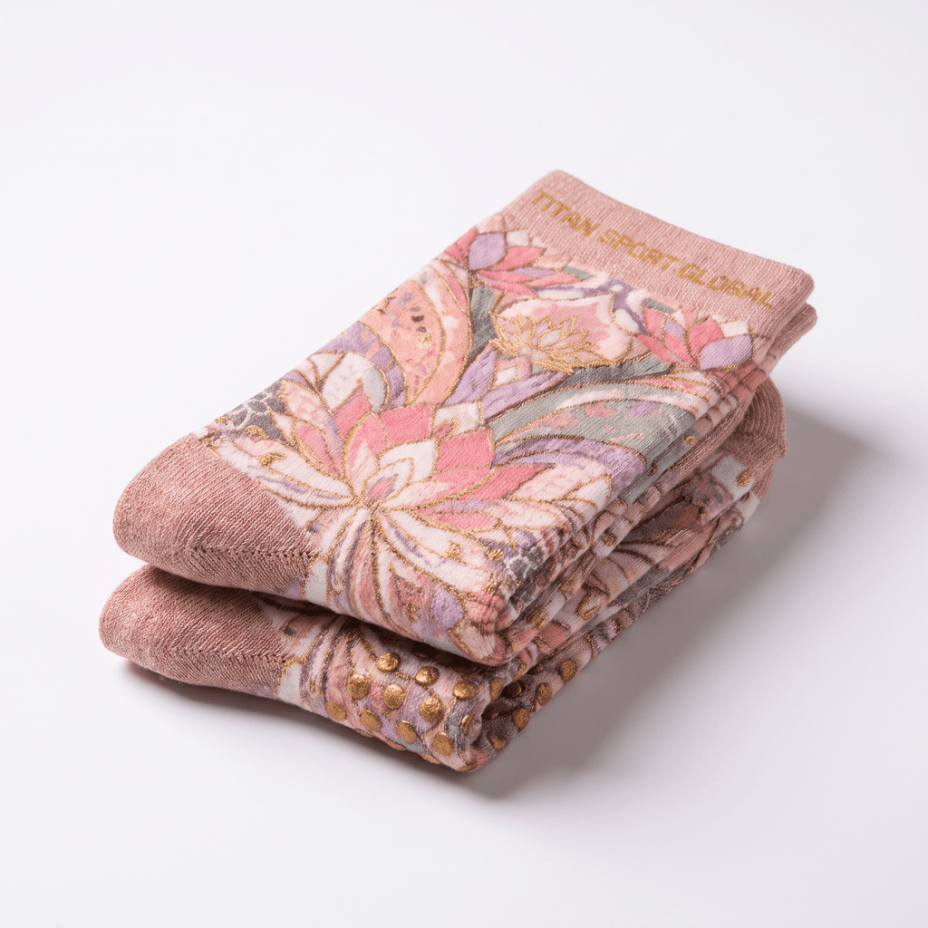 Folded pink yoga socks with a floral pattern and gold grip dots on the sole.