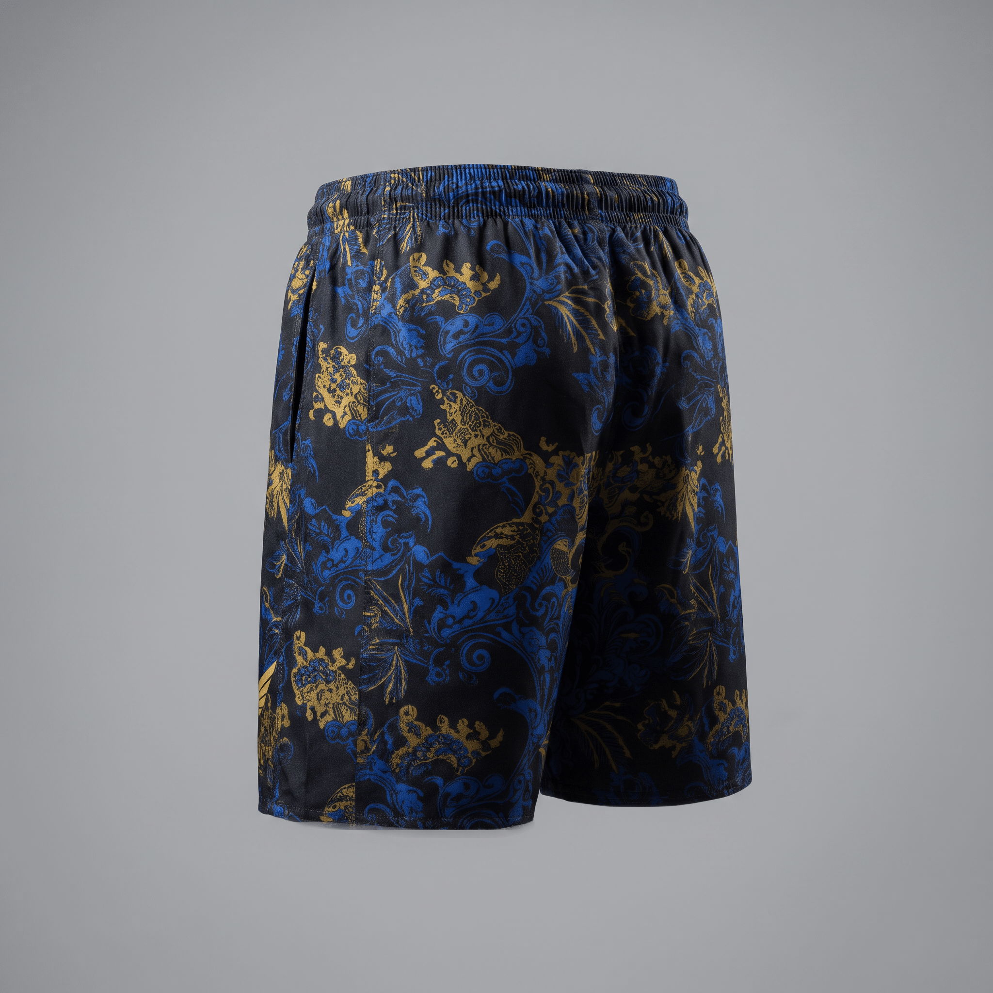 Back view of black athletic shorts with blue and gold ornate baroque print and elastic waistband.